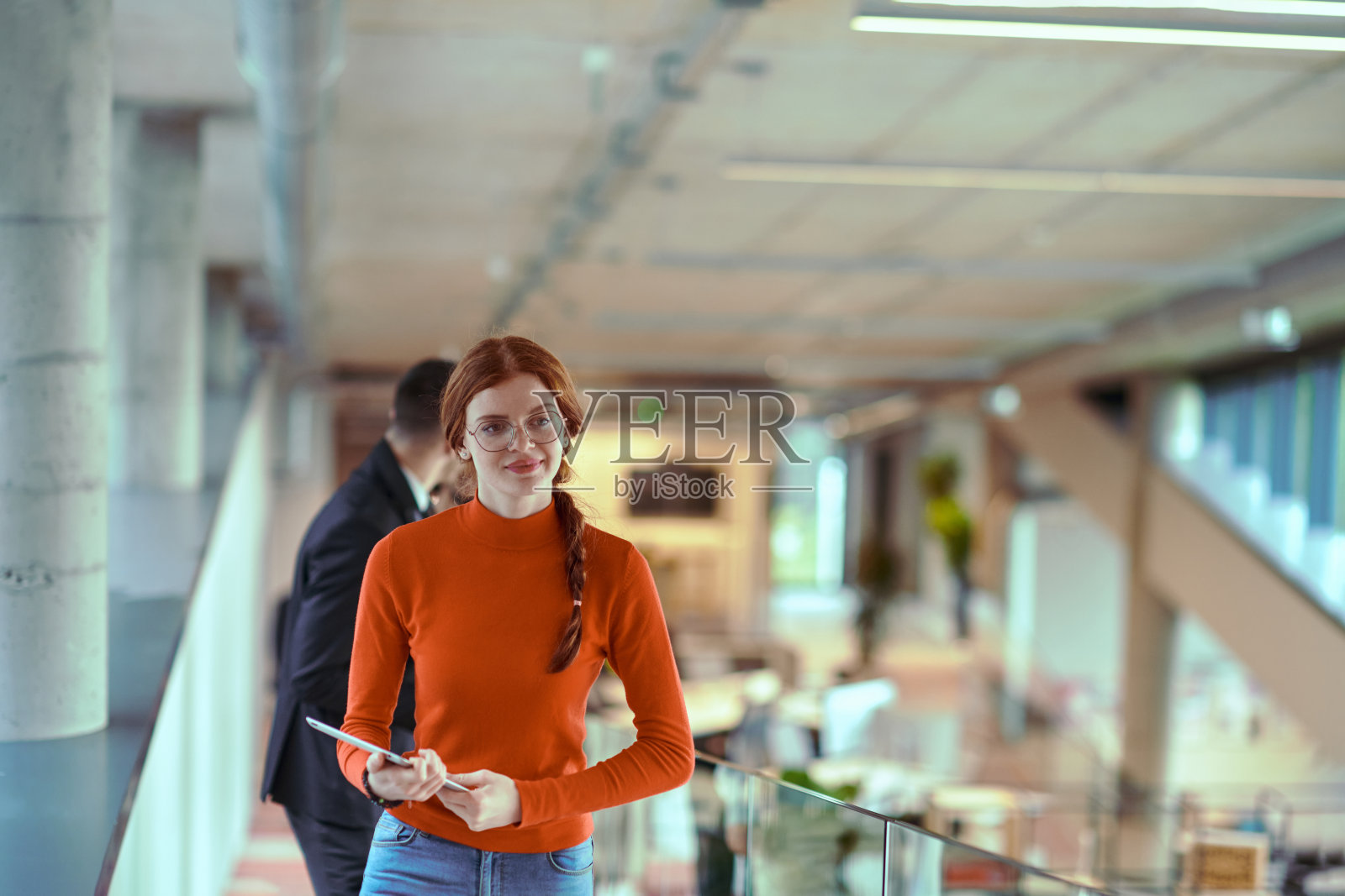 在一家现代创业公司的动态环境中，董事与年轻的商业同事边走边讨论，体现了他们正在进行的商业项目中的协作与创新精神。照片摄影图片