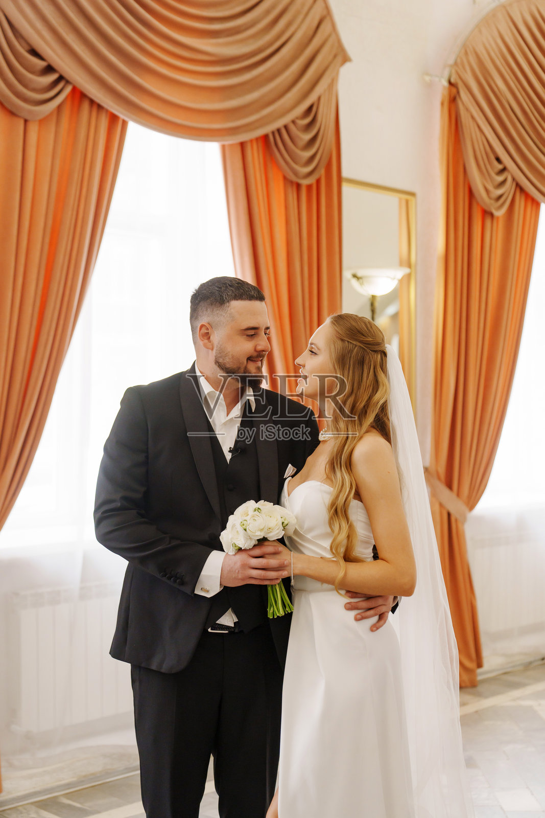 新郎新娘在婚礼宫大厅内。照片摄影图片