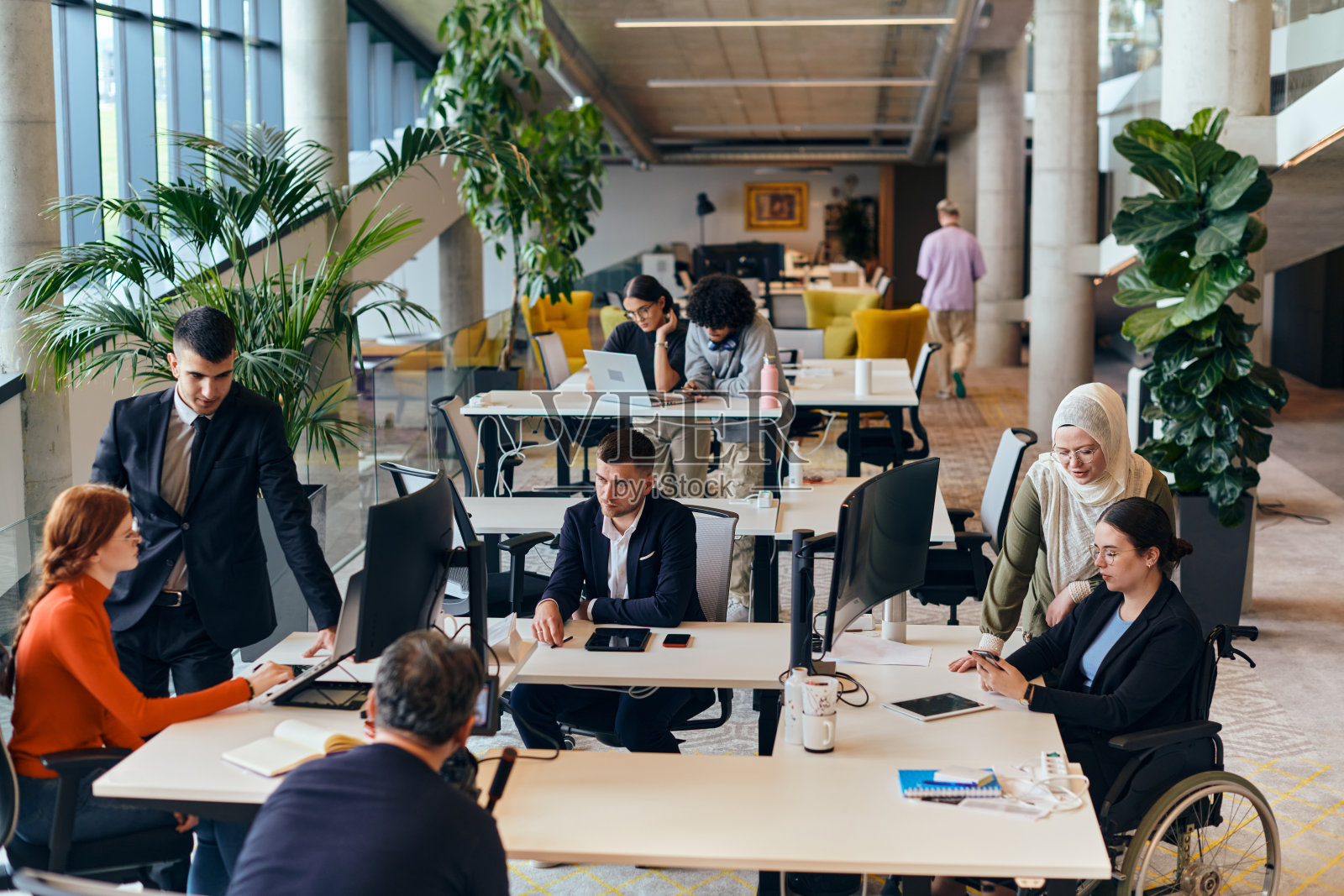 在现代创业公司办公室里，一群年轻多元化的专业人士共同协作，解决各种商业问题和挑战，周围有积极投入的同事，共同营造创新和高效的工作氛围。照片摄影图片