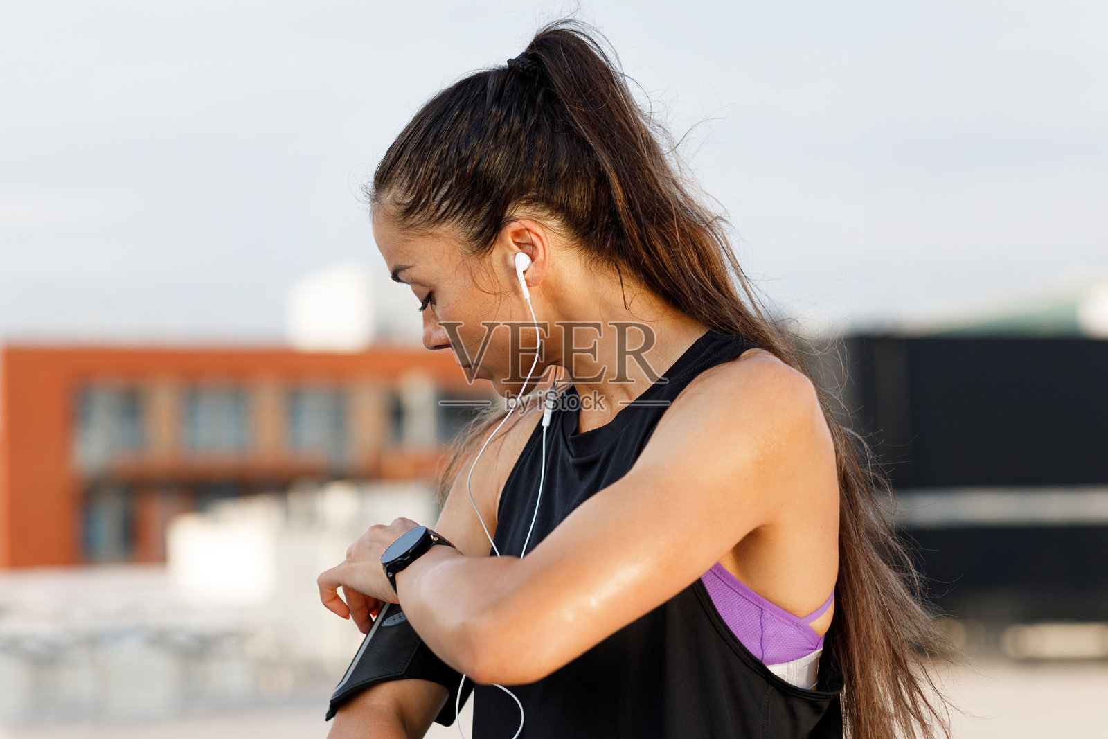 一名女性在锻炼时查看手腕上的运动手环照片摄影图片