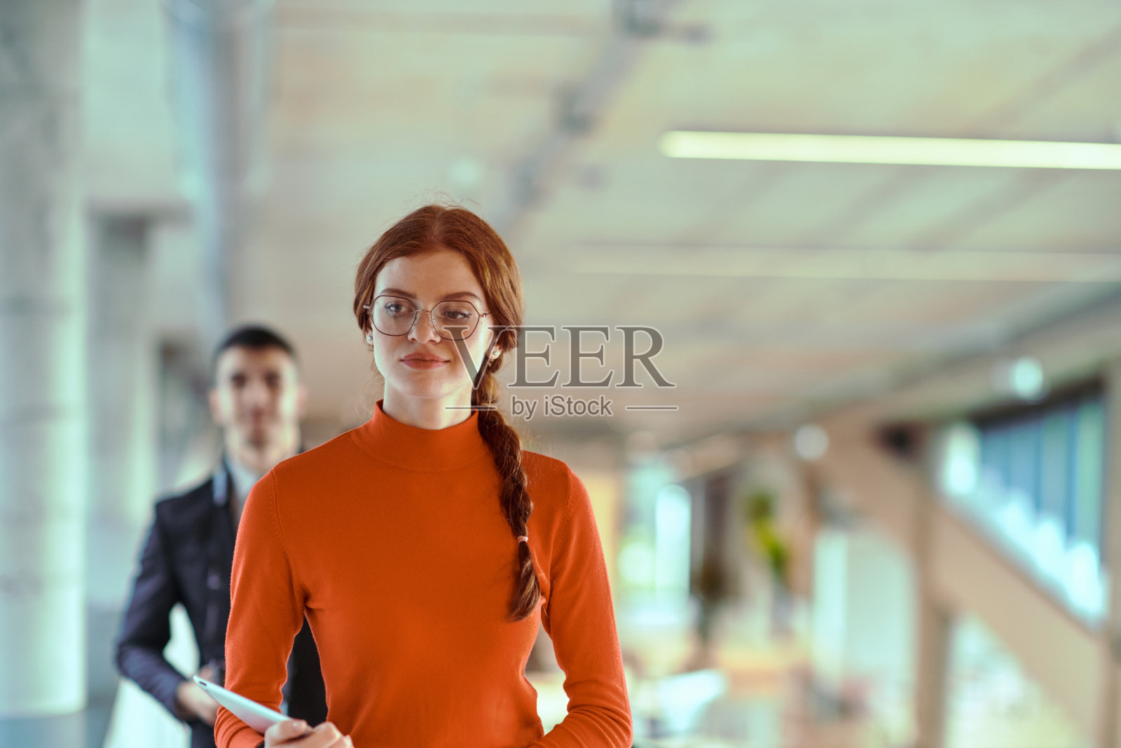 在现代创业公司充满活力的环境中，总监在与年轻的商业同事边走边讨论，体现了他们在持续的商业项目中的协作与创新精神。照片摄影图片