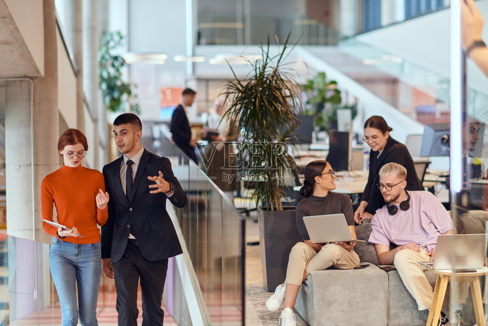 在现代初创公司办公室里，一群多元化的年轻专业人士正在与同事们一起，共同解决各种商业问题和挑战，以激发创新和提高生产力。照片摄影图片