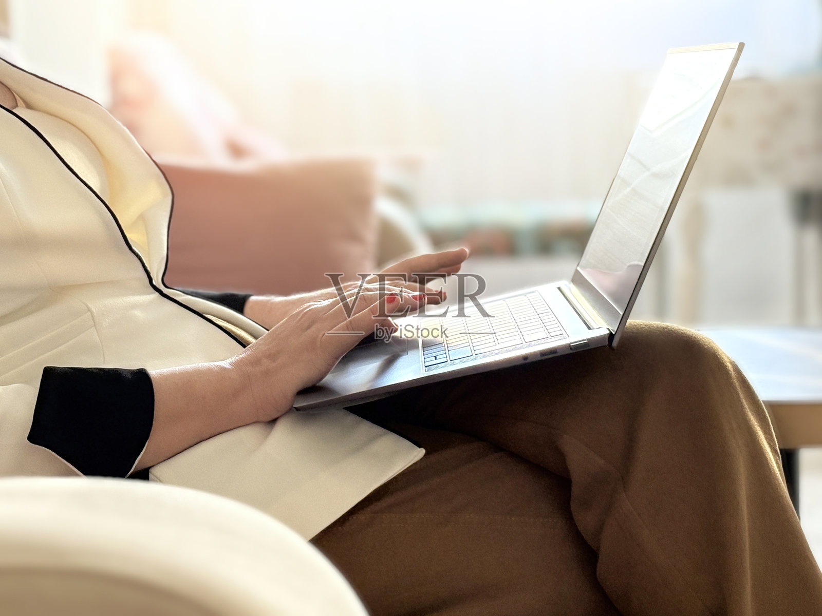 女人在家使用笔记本电脑。女商人用笔记本电脑在家工作。女人的手在笔记本电脑键盘上打字。女人用电脑进行网络连接、写博客或收发邮件，在家办公。照片摄影图片