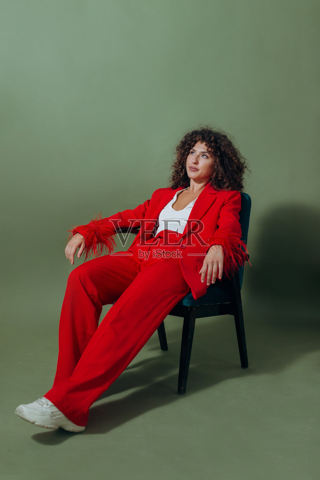 一个卷发年轻女子，身穿红色套装照片摄影图片