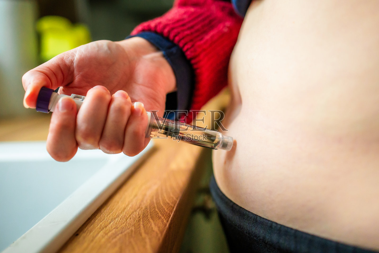 一位女士正在使用注射笔注射减肥药物照片摄影图片
