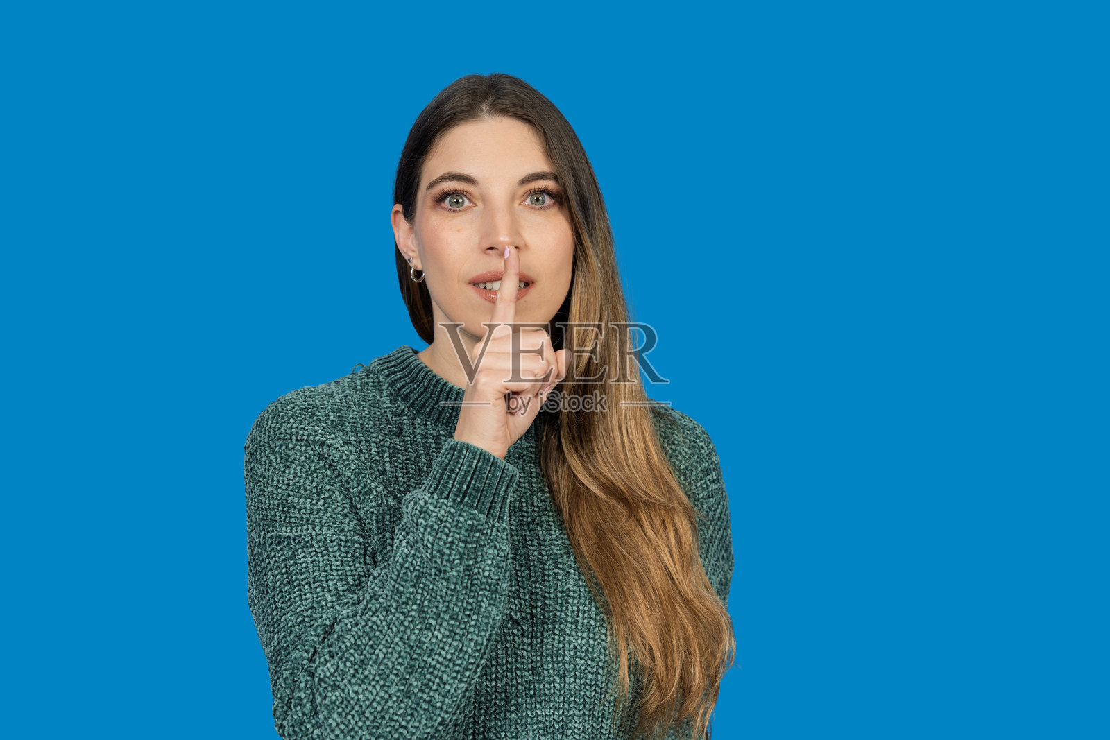 一位女士做出嘘声手势，要求保持安静照片摄影图片