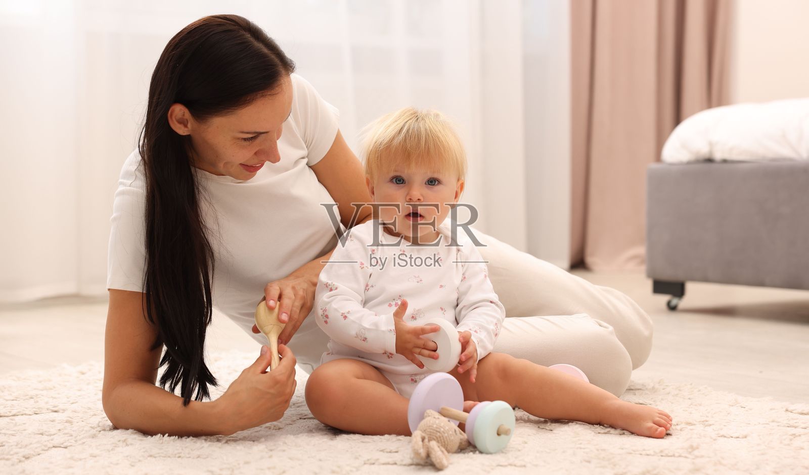 微笑的母亲在家地板上和可爱的宝宝玩耍照片摄影图片