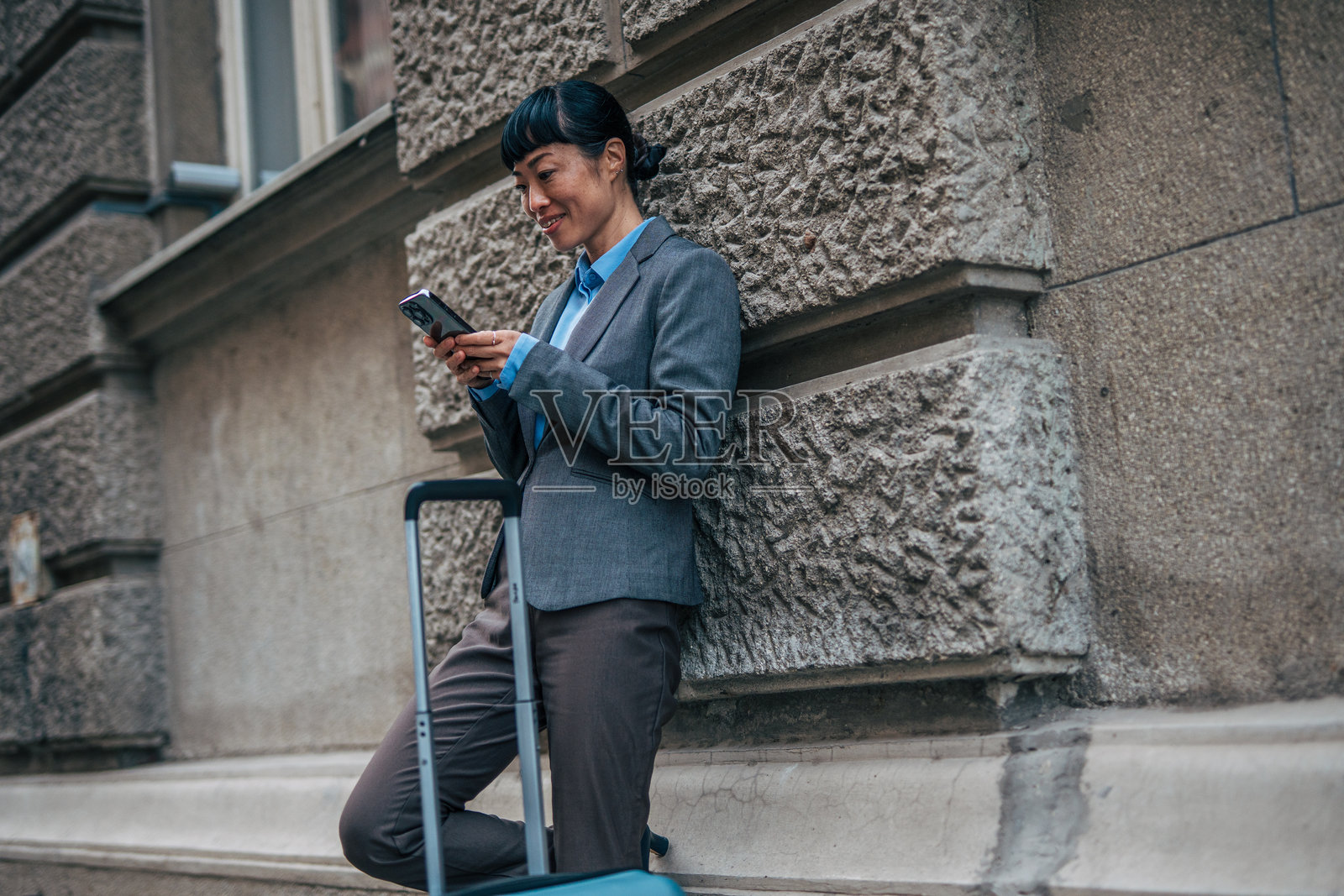 商务女性在城市中使用智能手机旅行照片摄影图片