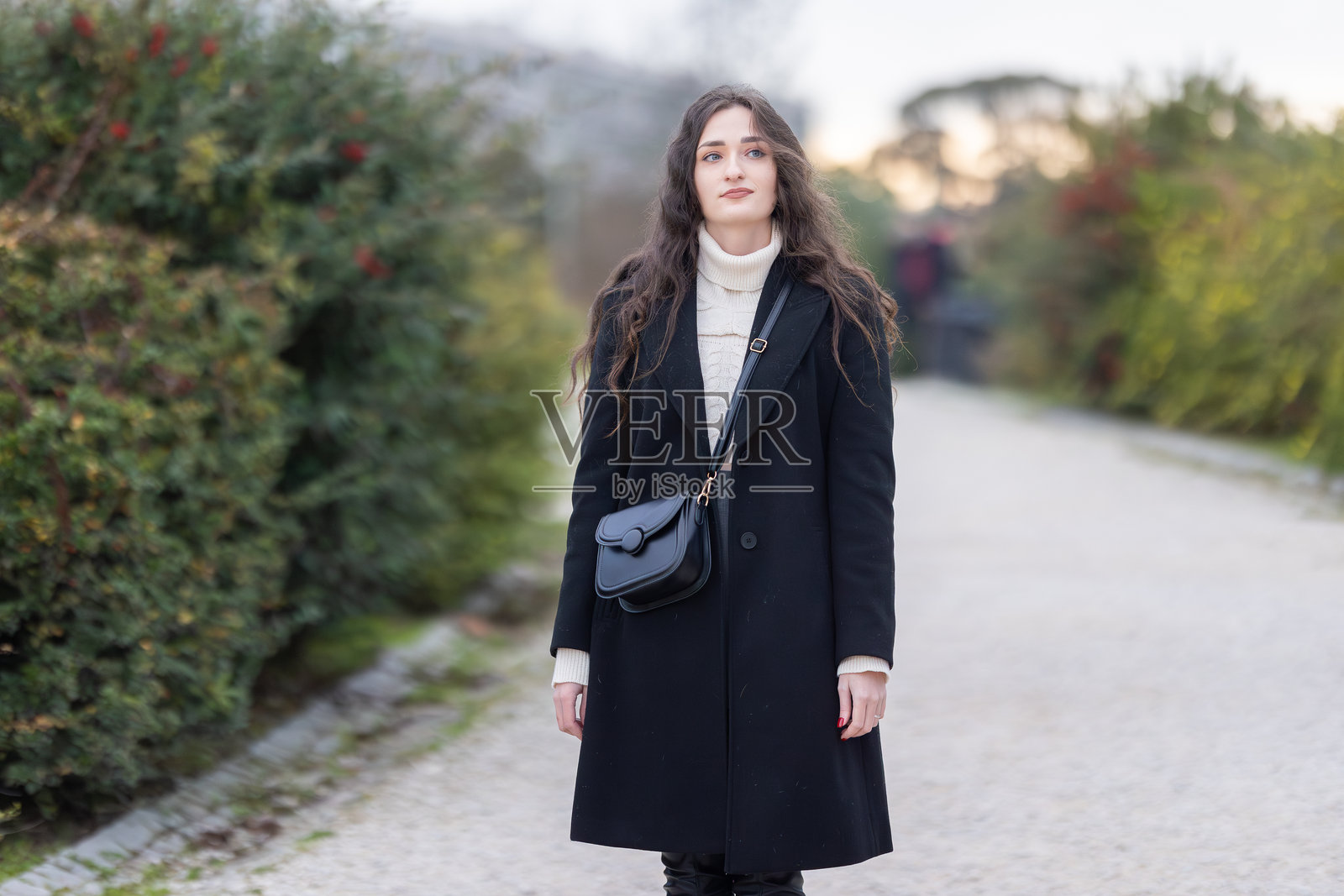 身穿黑色外套和高领衫的女性在公园（Woman wearing black coat and turtleneck in park）照片摄影图片