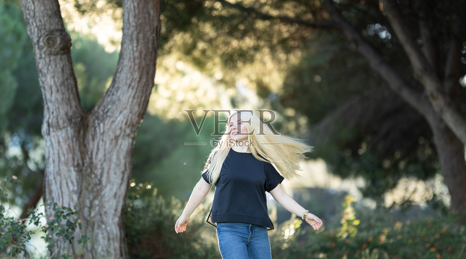 女人在公园的树林中行走照片摄影图片