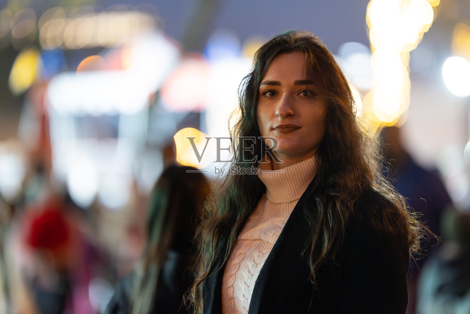 年轻女子在夜晚的城市街道上看向镜头照片摄影图片