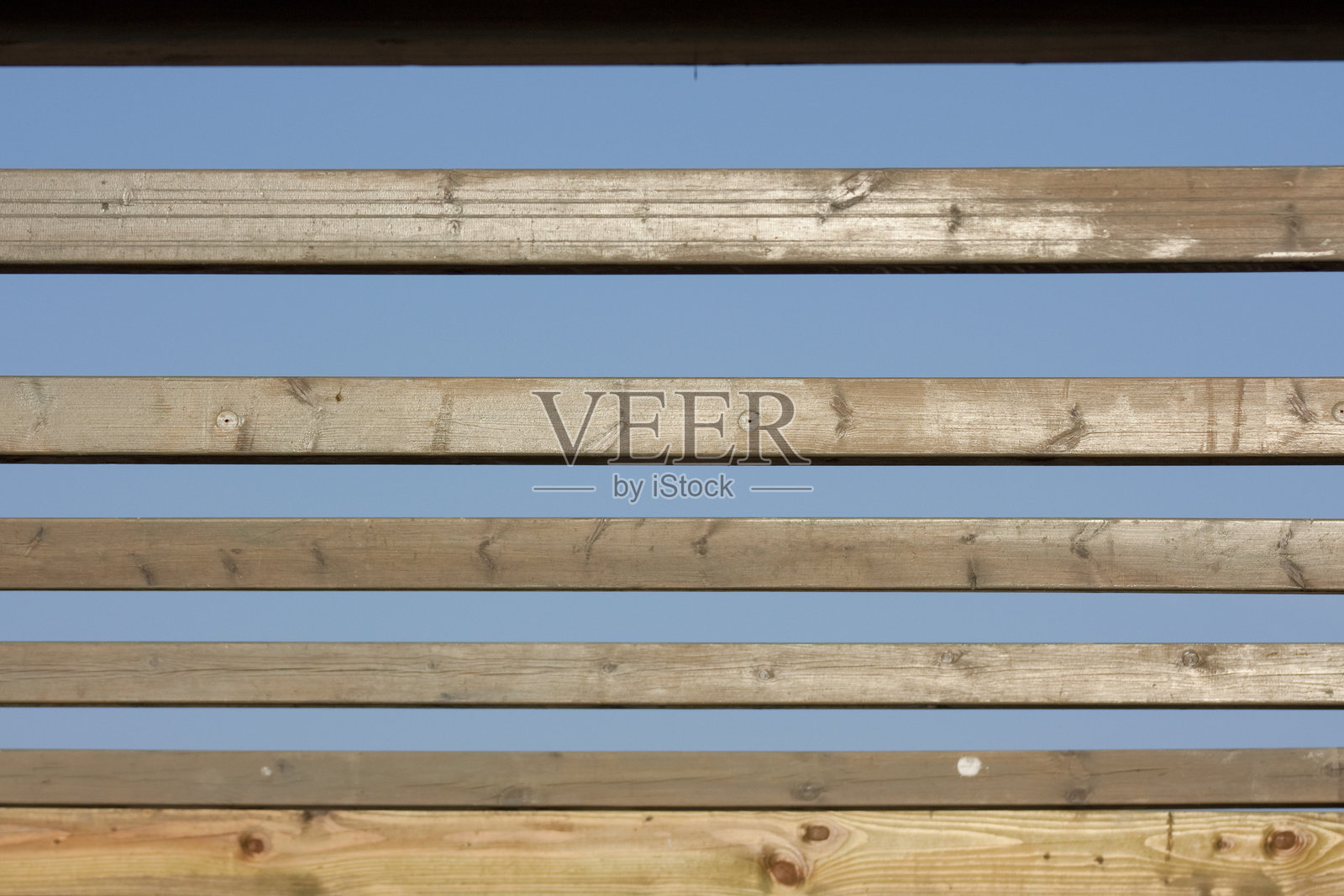 木板条在蓝天背景下构成抽象图案照片摄影图片