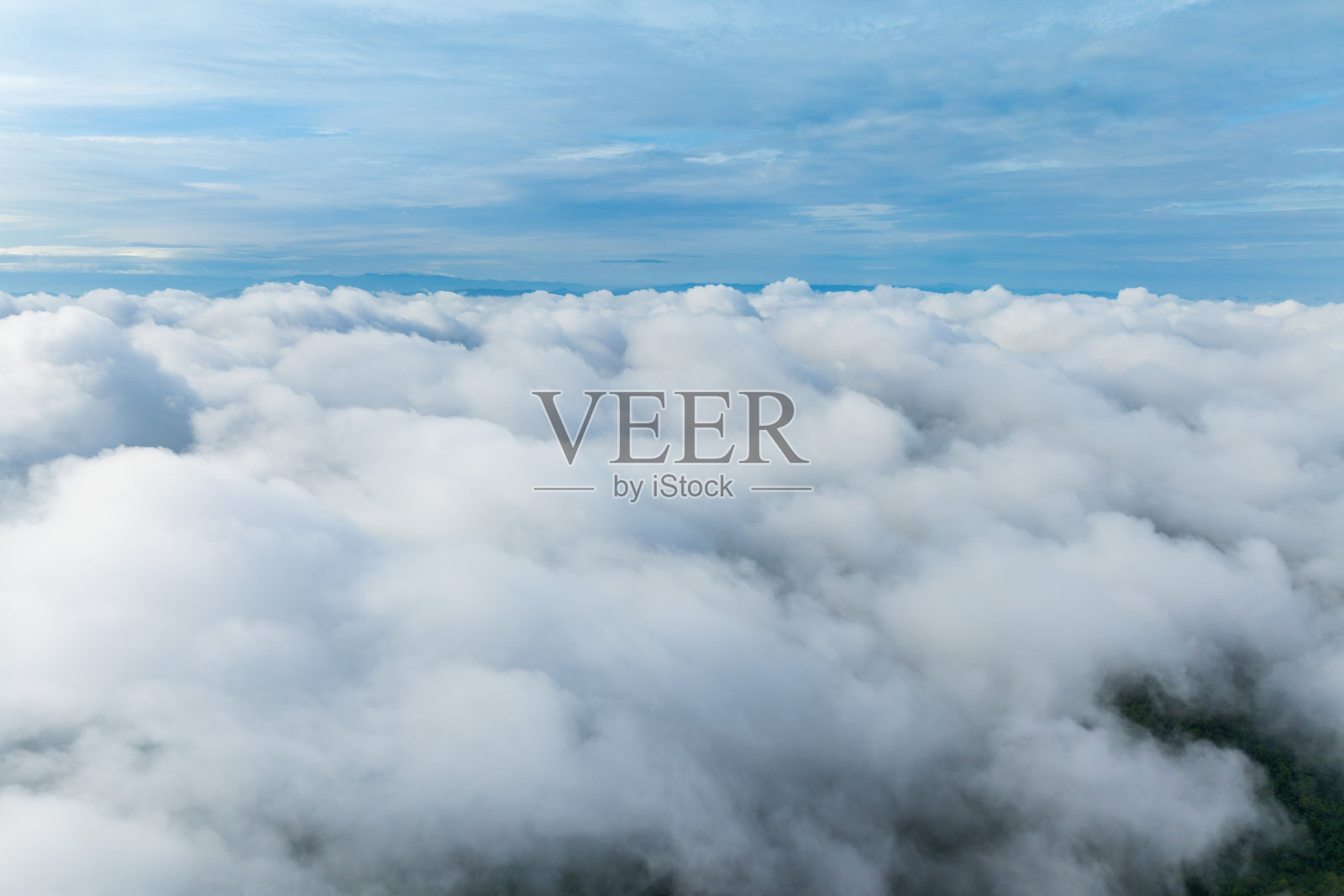 浓雾和云层掠过绿色山谷及远山的戏剧性航拍景象，地平线在广阔的云层天空下若隐若现。壮丽的高角度自然风光。照片摄影图片