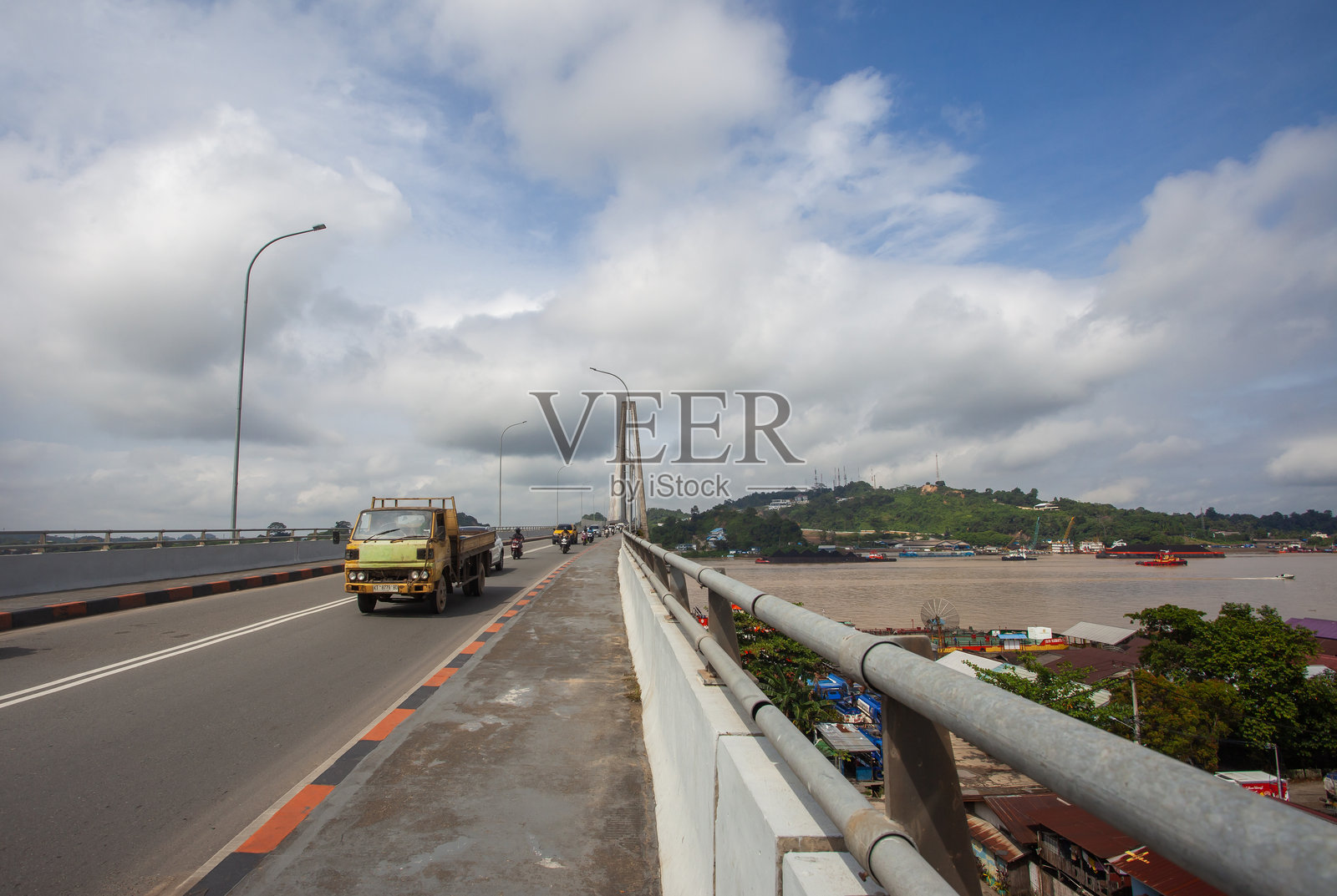 印度尼西亚三马林达马赫科塔二桥的道路视角。日常交通繁忙，横跨河流，彰显了这座桥梁在城市交通中的重要作用。照片摄影图片