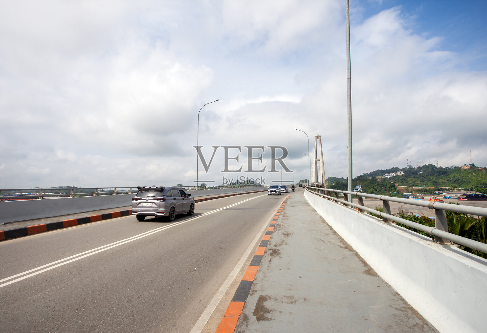 印度尼西亚三马林达马赫科塔二桥的道路视角。日常交通混合穿行于河流之上，凸显了这座桥梁在城市交通中的重要作用。照片摄影图片