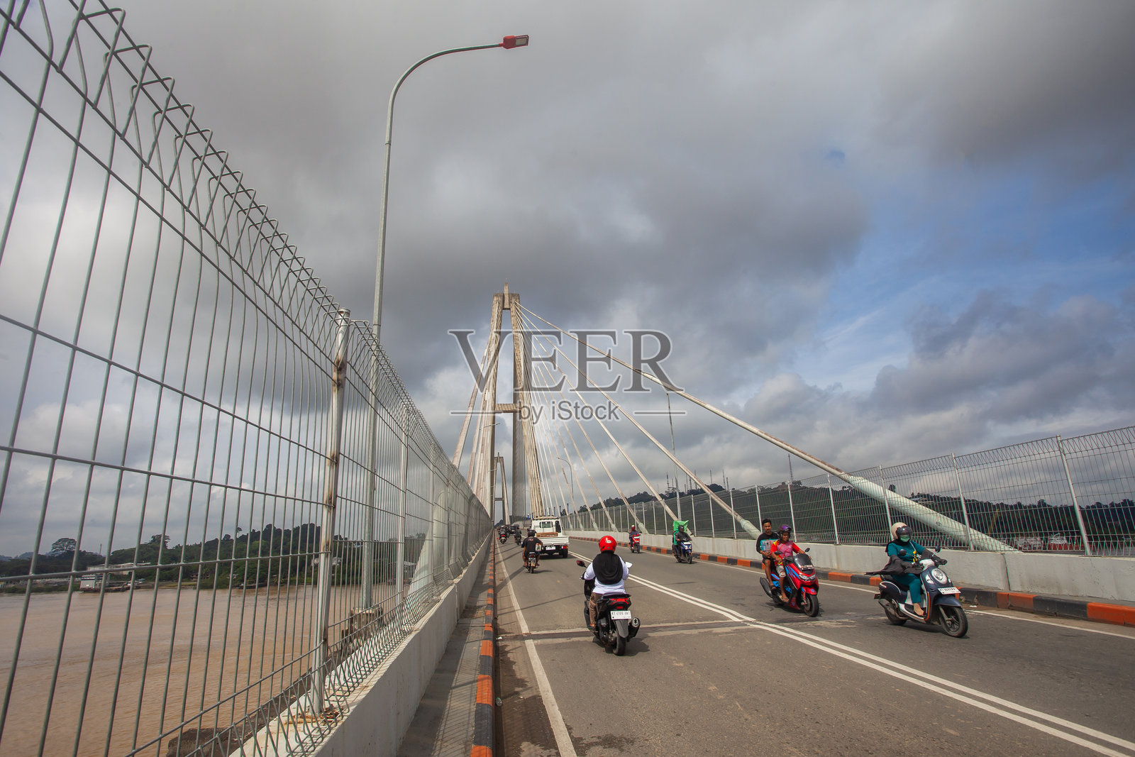 印度尼西亚三马林达马赫科塔二桥的公路景观。日常车流穿梭于河流之上，凸显了这座桥梁在城市交通中的关键作用。照片摄影图片