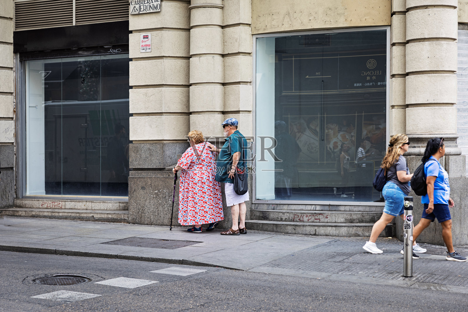 西班牙马德里，几位年长居民在城市街道上互动照片摄影图片