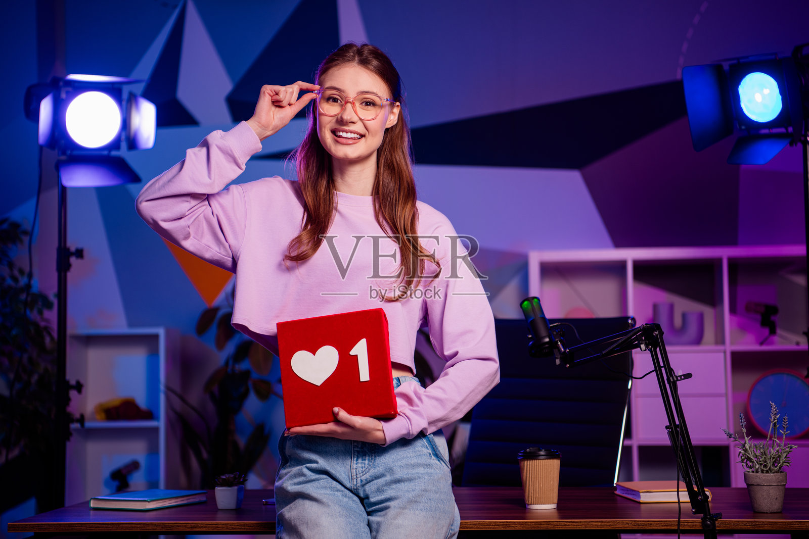 一位年轻的女视频博主在霓虹灯房间里，以迷人的积极个性制作引人入胜的内容，并配有饰品。照片摄影图片