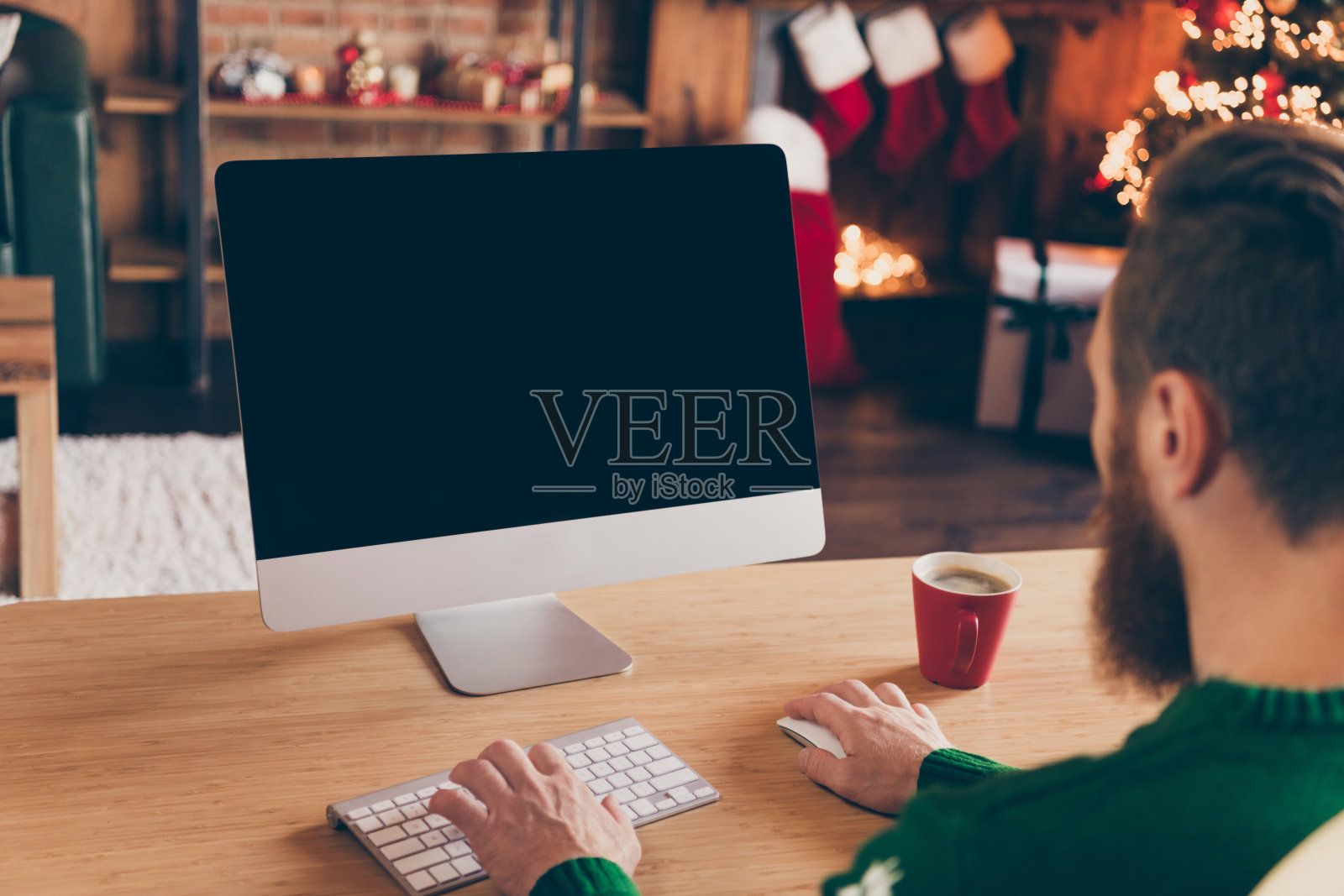 穿着毛衣的程序员在办公室低头工作，这是他背部对着镜头的照片，他看起来很专注，办公室室内。照片摄影图片