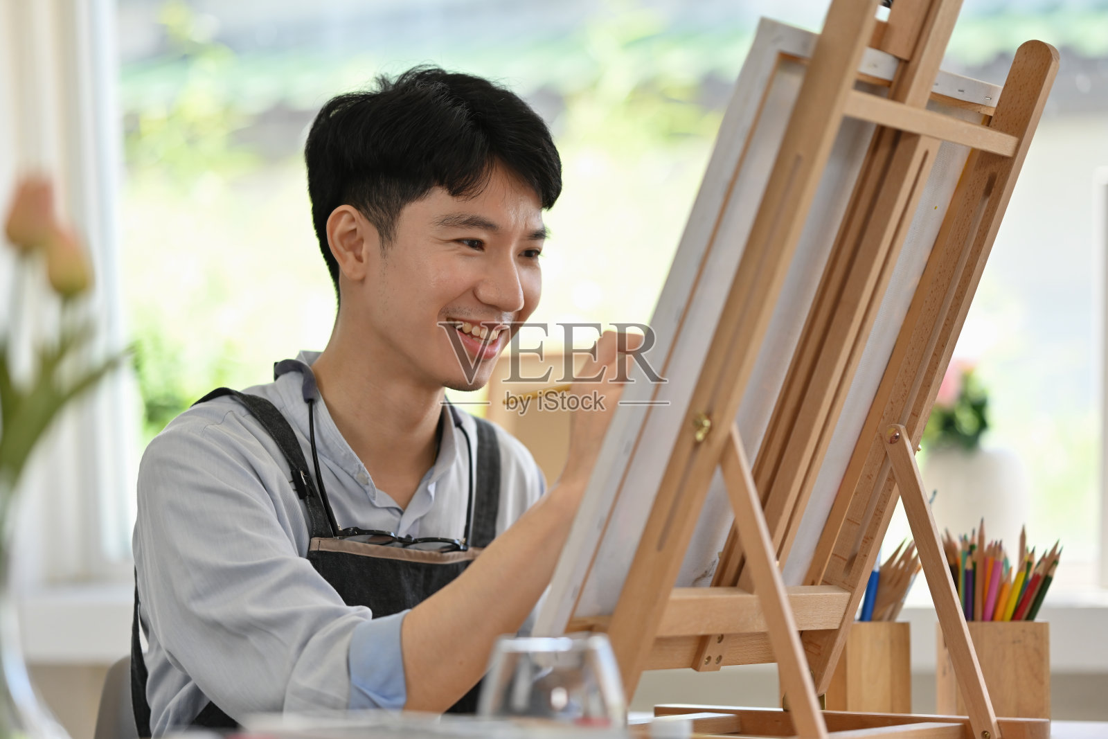 年轻男艺术家在工作室绘画，创意工作室瞬间照片摄影图片