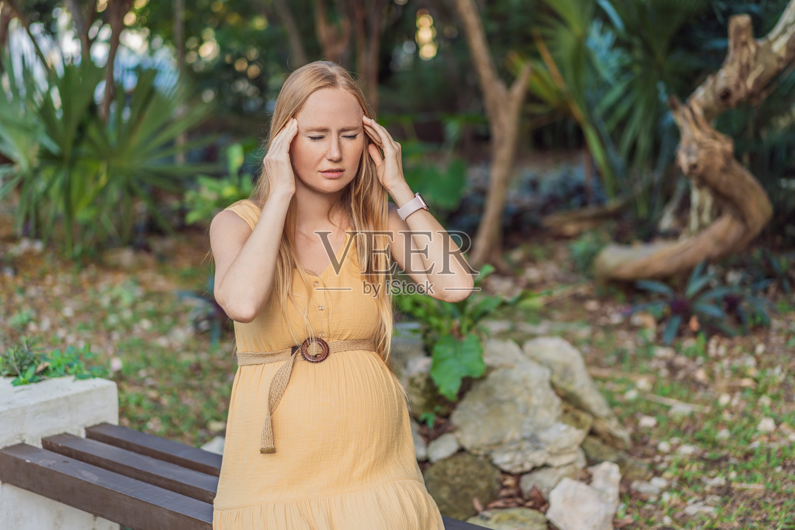 孕妇在孕期经历头痛的不适，这突显了孕期常见的挑战以及对孕期自我护理和母婴健康关注的必要性。照片摄影图片