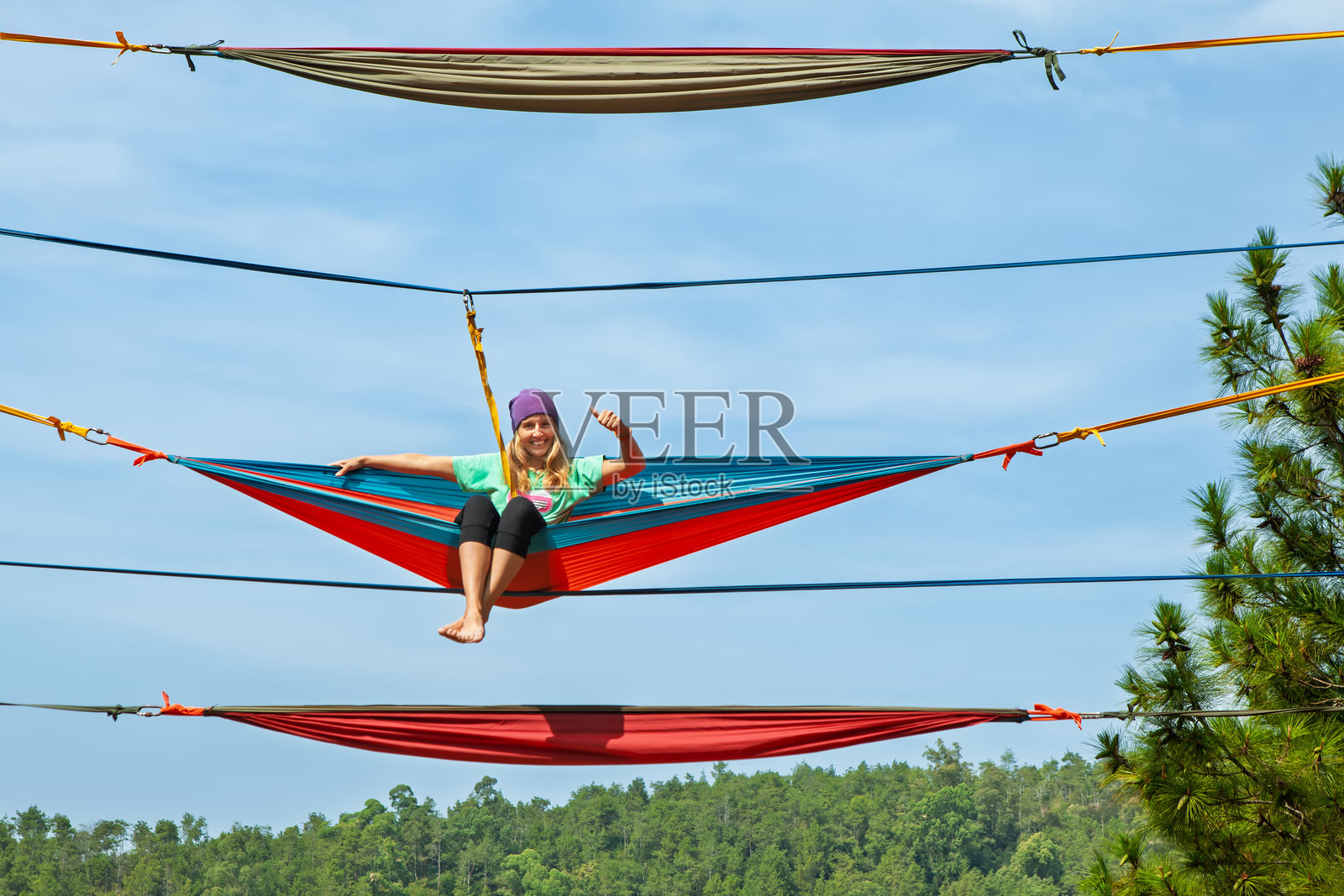 年轻女子在高空中吊床放松。印度尼西亚独特的や高空景点，提供刺激的体验和热带雨林的壮丽景色，适合冒险度假。旅行，度假。照片摄影图片