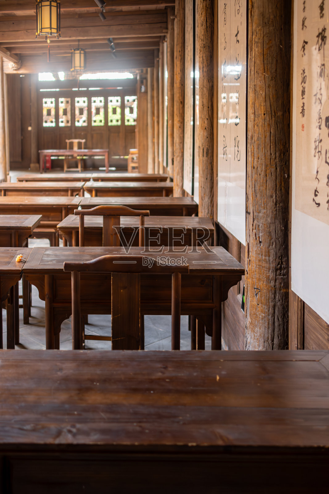 古老的学堂：一间永恒的教室里摆放着传统的木制书桌和书法卷轴照片摄影图片