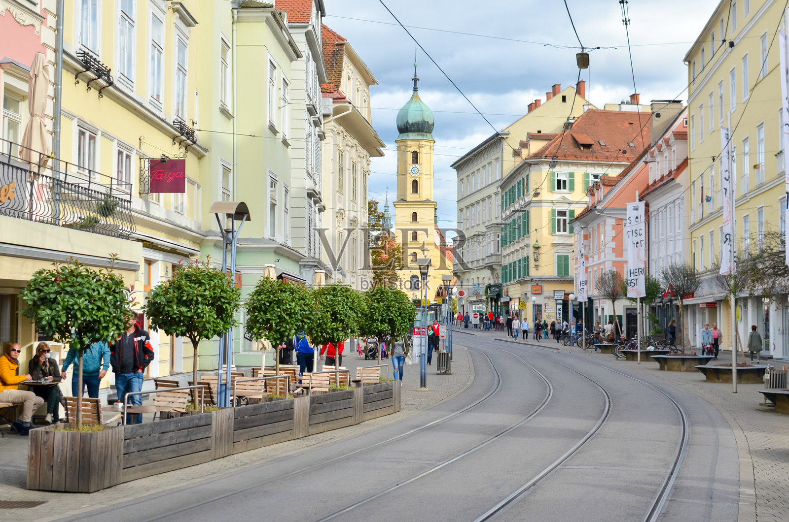 奥地利格拉茨 – 2017年10月：格拉茨街景，背景有电车轨道、色彩缤纷的建筑和教堂塔楼照片摄影图片