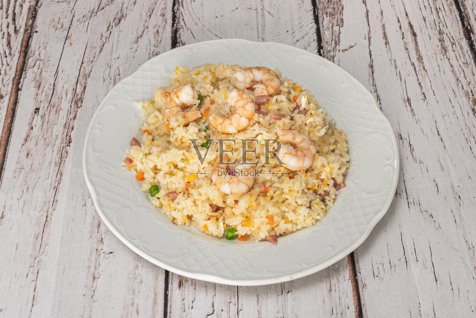 新鲜烹制的虾仁炒饭盛放在白色木桌上照片摄影图片