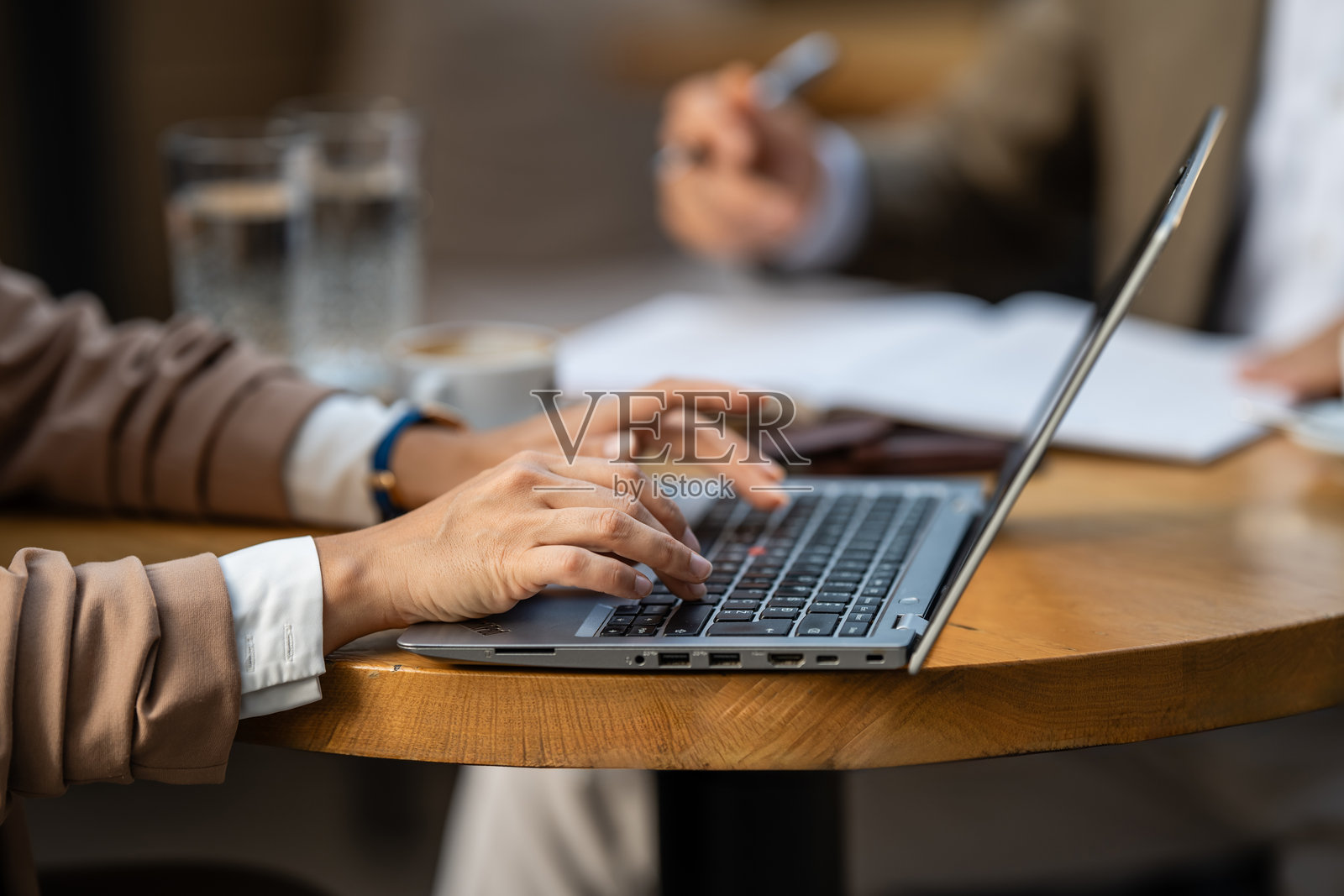 商务女性在咖啡馆开会时用笔记本电脑打字照片摄影图片