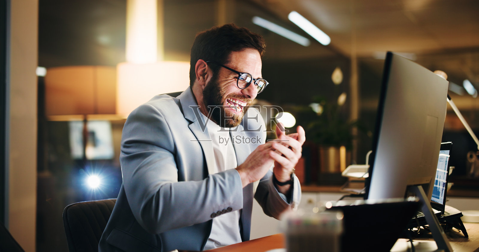 商人，夜晚的掌声和电脑，庆祝股票交易获利。会计师，投资者，在金融机构为成就、胜利和成功而兴奋地使用个人电脑。照片摄影图片