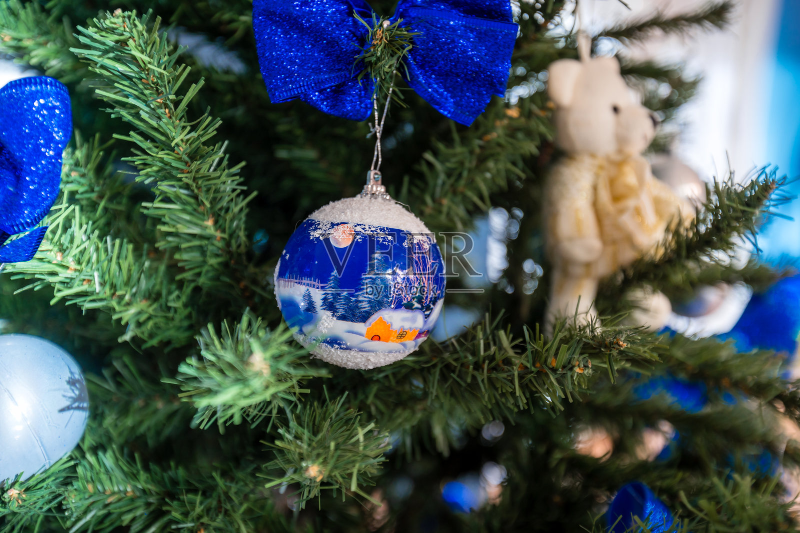 一个蓝色的雪花装饰挂在圣诞树上照片摄影图片