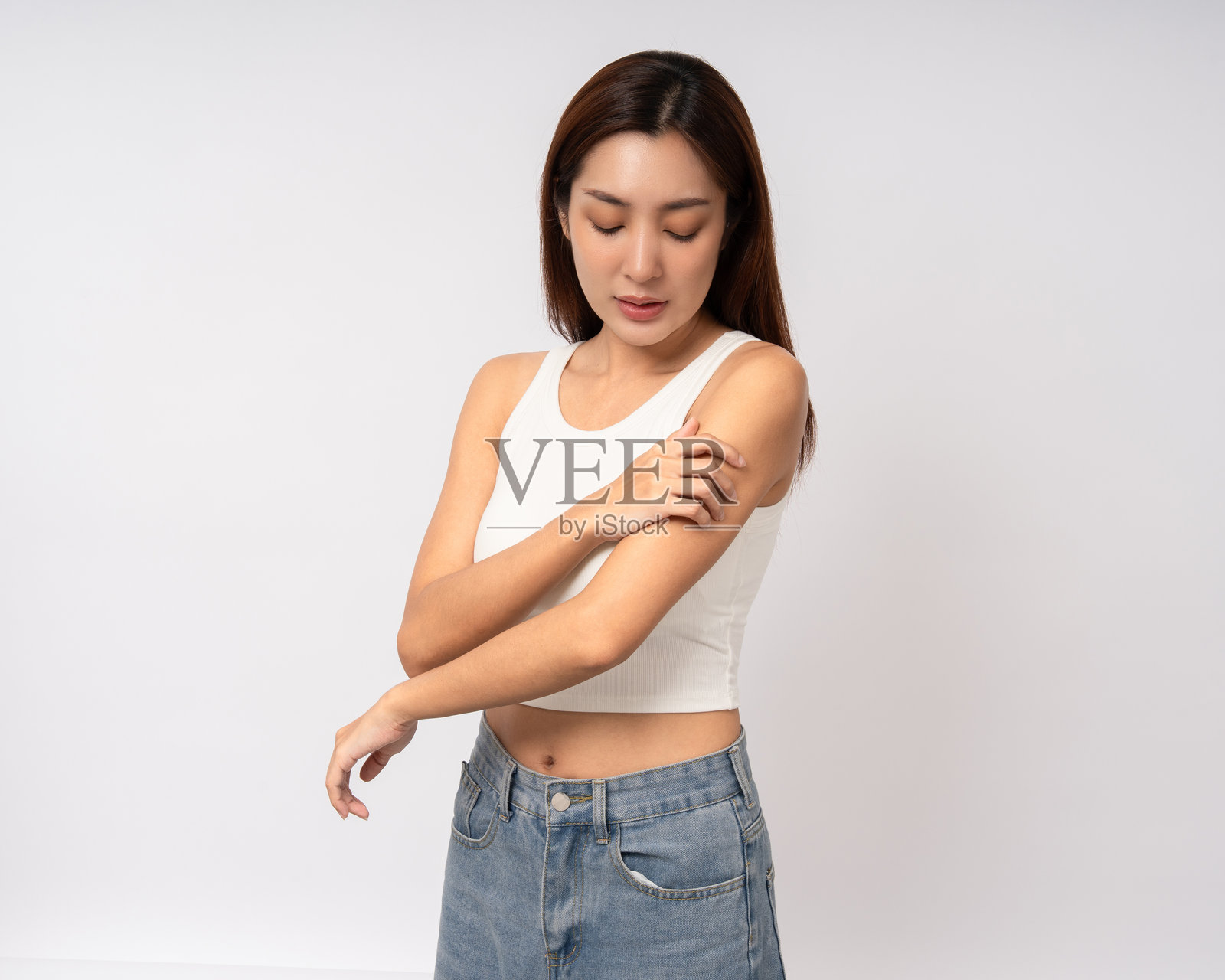 亚洲女性有皮肤问题，她感到皮肤刺激、皮肤感染、发痒、红疹，并用手抓挠。一位不适、不健康的女性站立在孤立的背景上。照片摄影图片