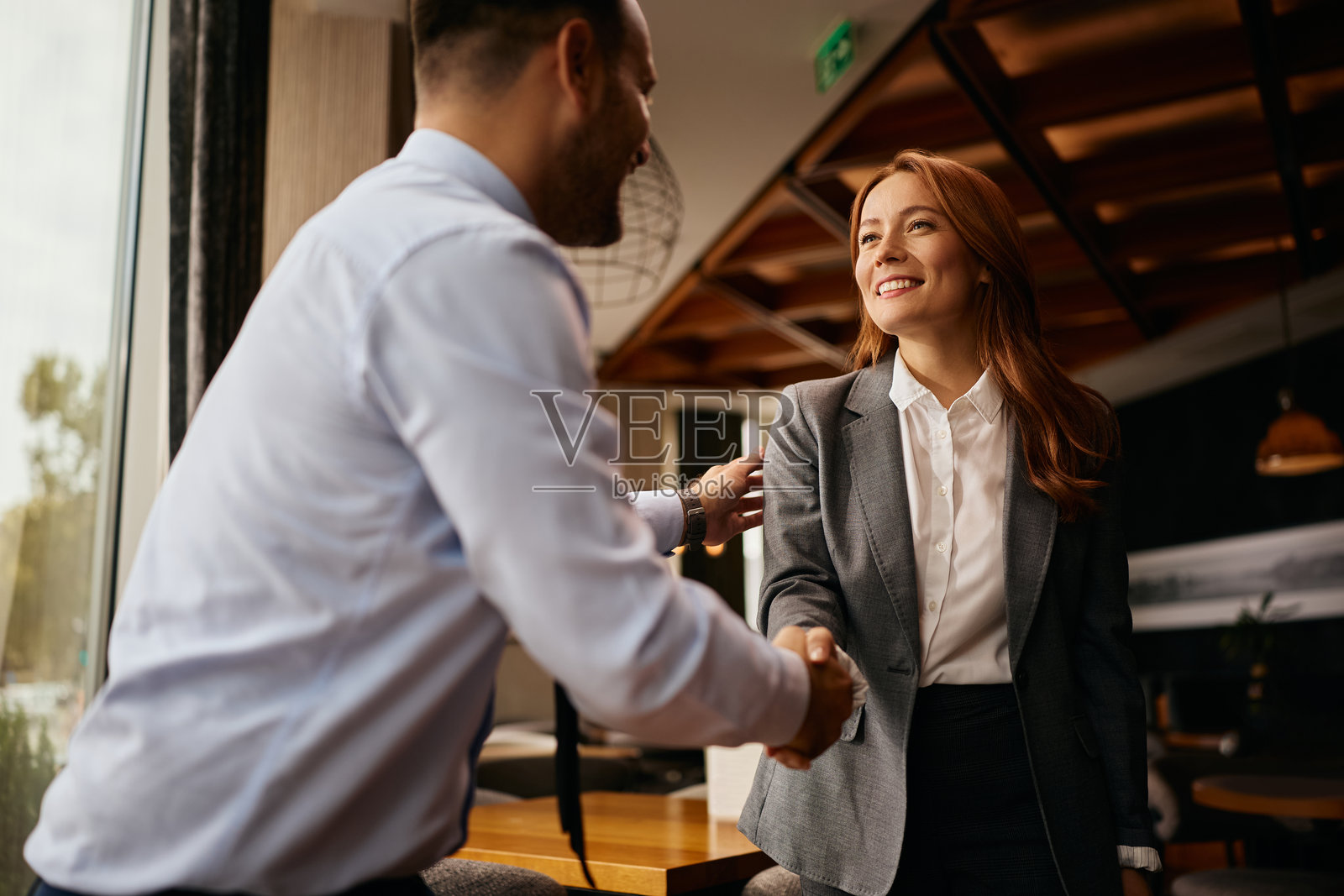 快乐的商务同事在咖啡馆见面时握手照片摄影图片