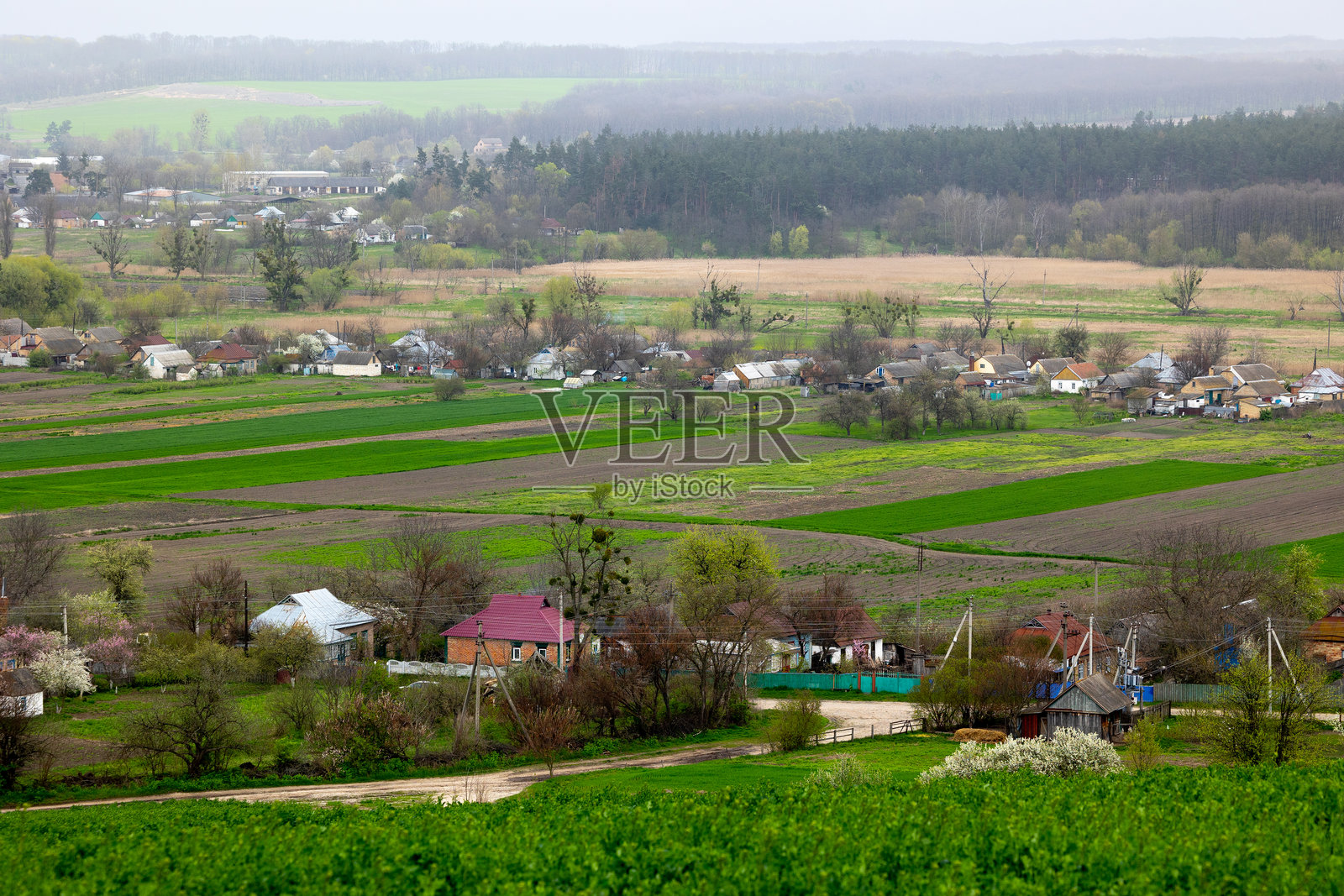 春末四月，乌克兰切尔卡瑟地区米利耶夫村扎赫列贝利亚的景色。房屋坐落在维尔尚卡河岸边，四周是绿色的田野和山丘。照片摄影图片