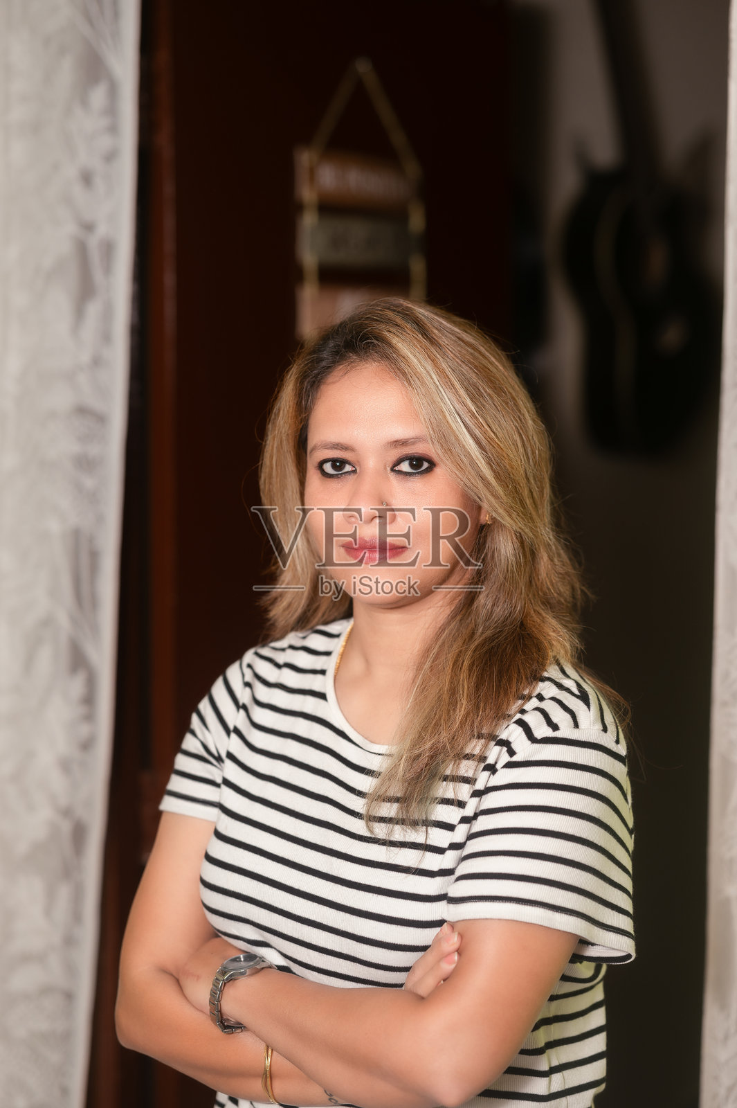 自信的女性双手交叉站立在室内照片摄影图片