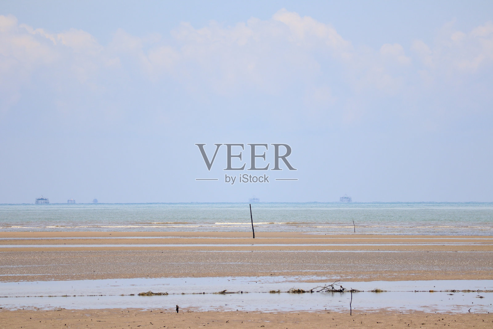 低潮时宽阔的沙滩，远处是平静的蓝色海平线照片摄影图片