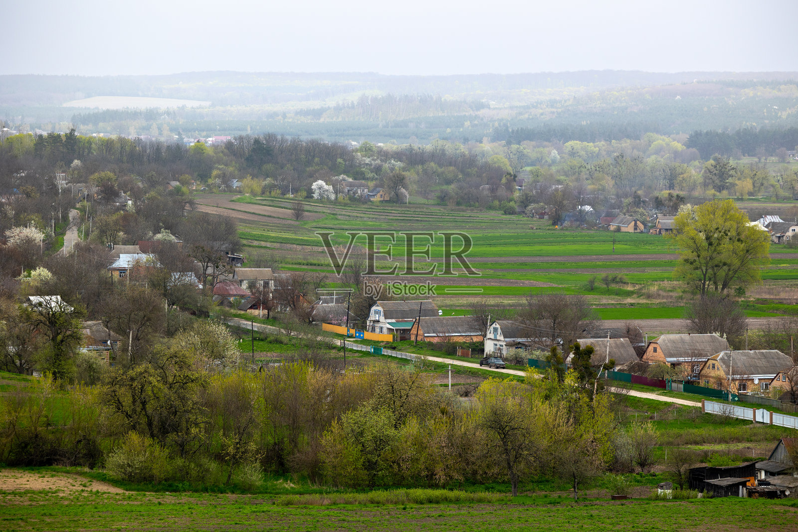 乌克兰切尔卡瑟地区米利耶夫村扎赫列别利亚的景色。房屋位于维利尚卡河畔，周围环绕着春季四月下旬的绿色田野和山丘。照片摄影图片