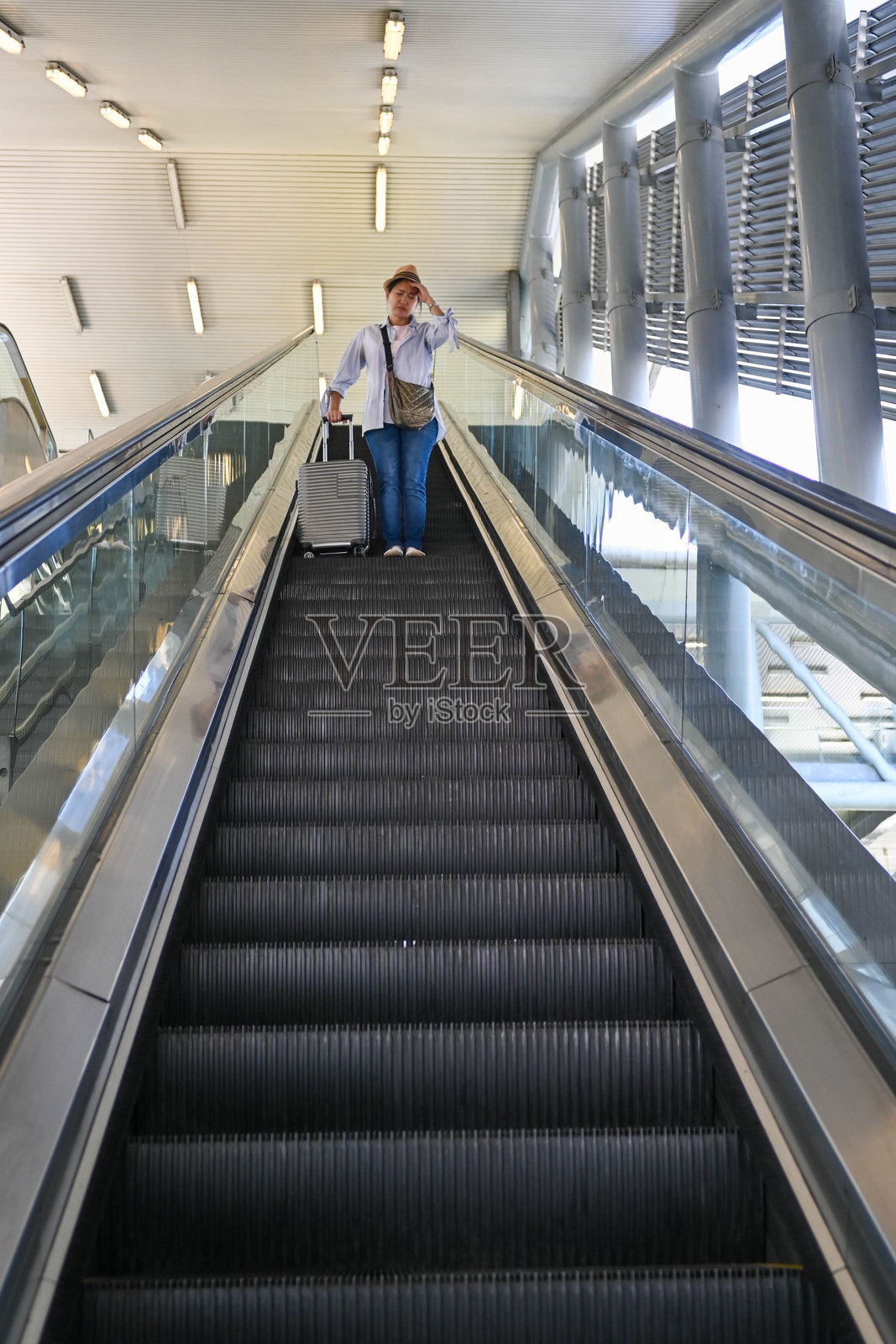 生病的旅客在机场自动扶梯上照片摄影图片