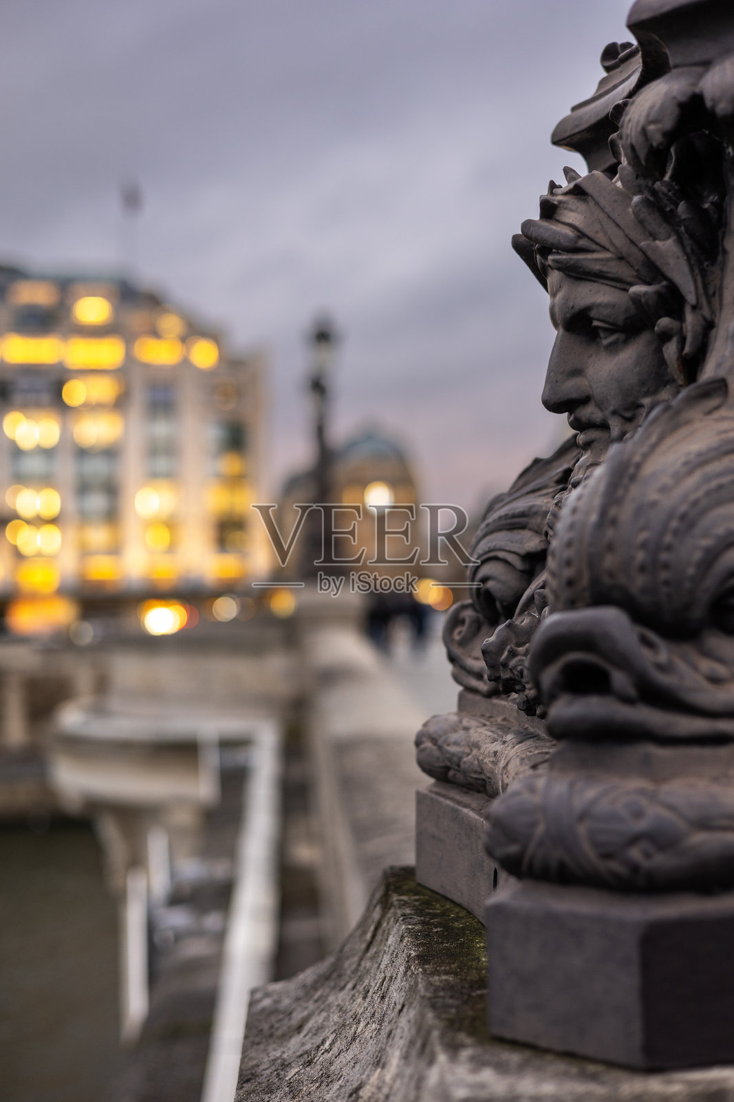 法国巴黎新桥上一个华丽古老灯柱的特写。铸铁基座饰有怪诞的假面雕饰和海洋生物。照片摄影图片