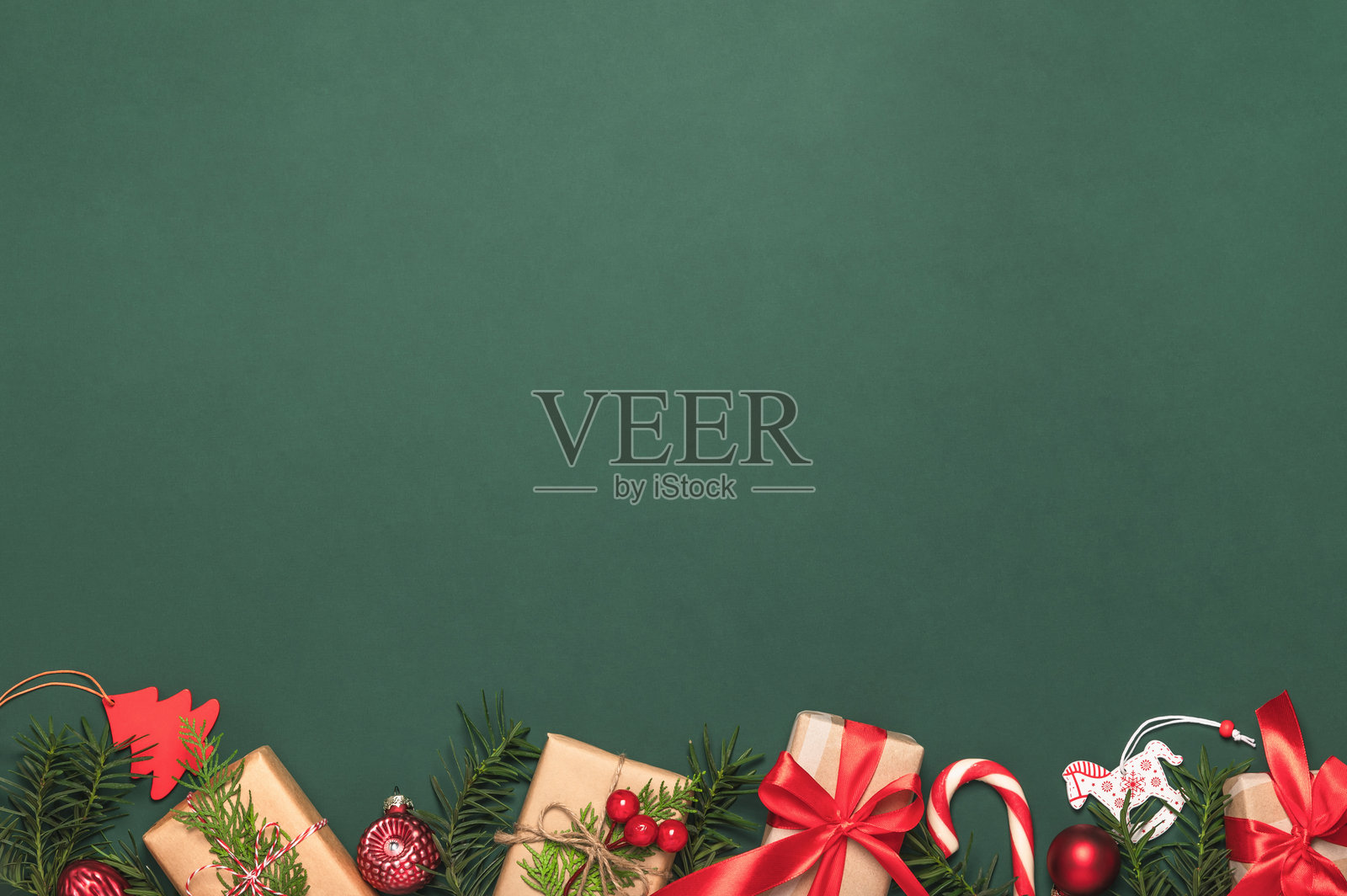 圣诞贺卡，框架，背景有松枝、纸质礼品盒和红色拐杖糖。留有复制空间。照片摄影图片