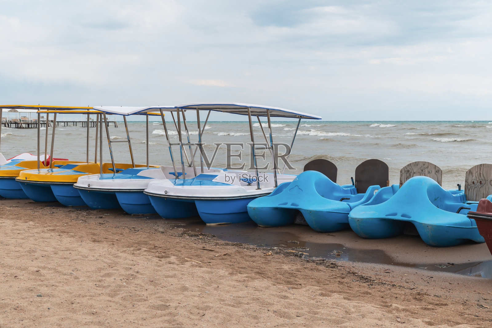 吉尔吉斯斯坦伊塞克湖上的愉悦双体船在沙滩上，以及风暴波浪。照片摄影图片