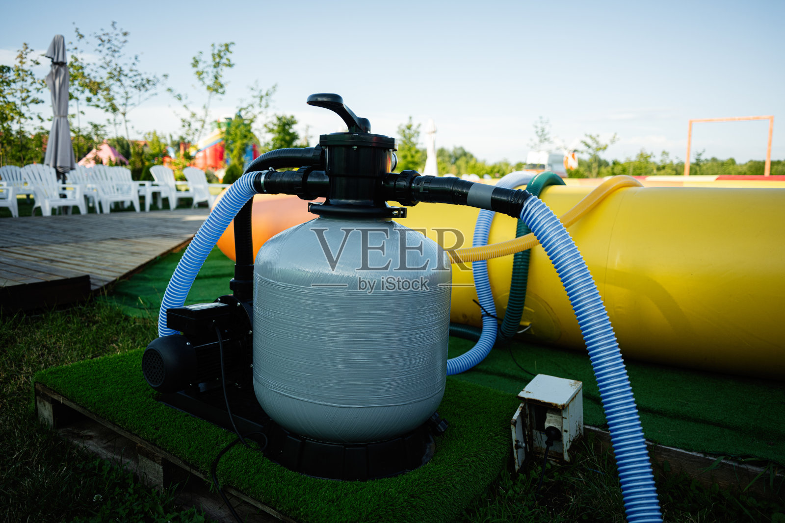 泳池设备户外设置，包括过滤系统和彩色充气玩具照片摄影图片