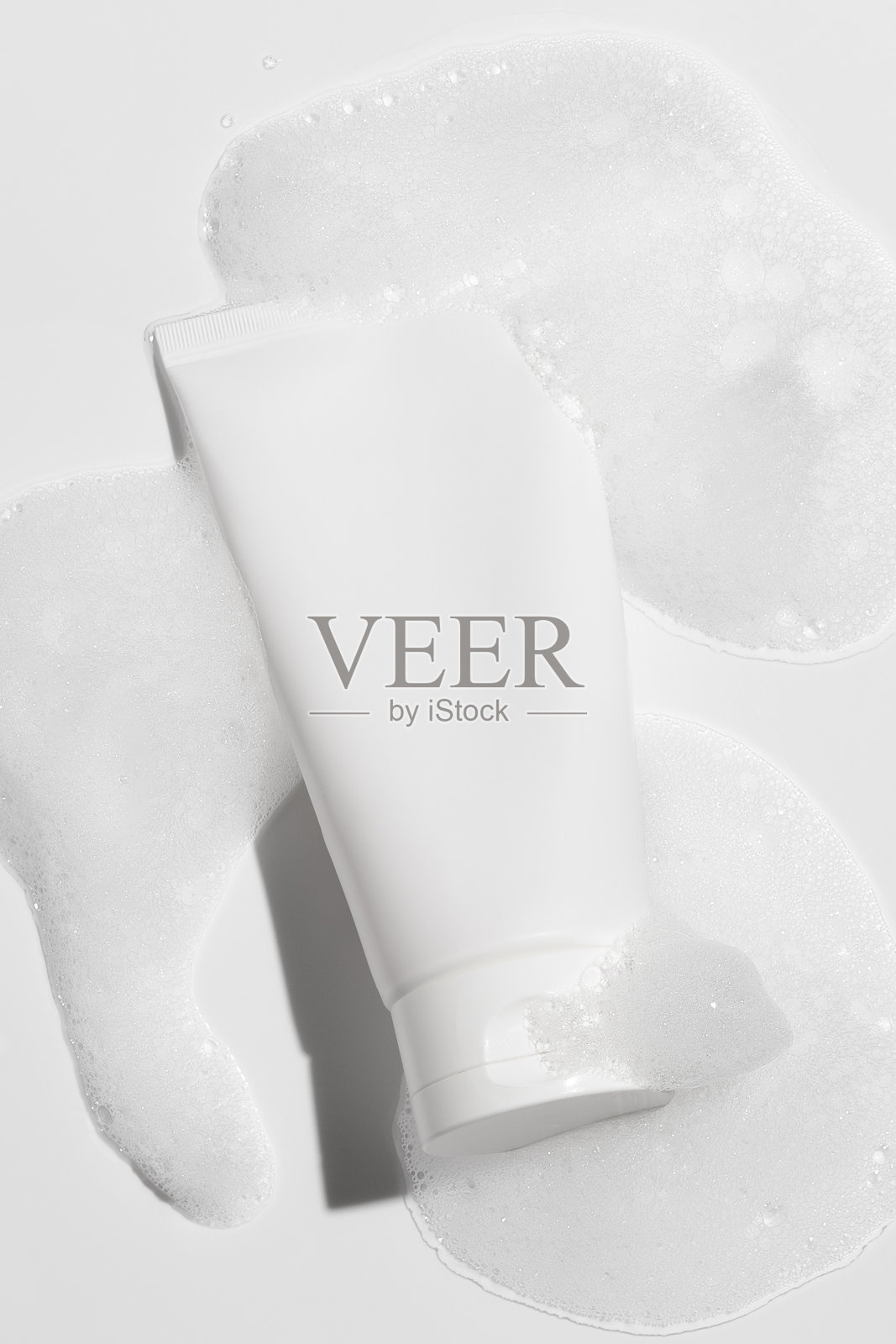 化妆品空白色塑料管，背景为泡沫。模型图。用于宣传和推广面霜、凝胶、精华液的包装。照片摄影图片