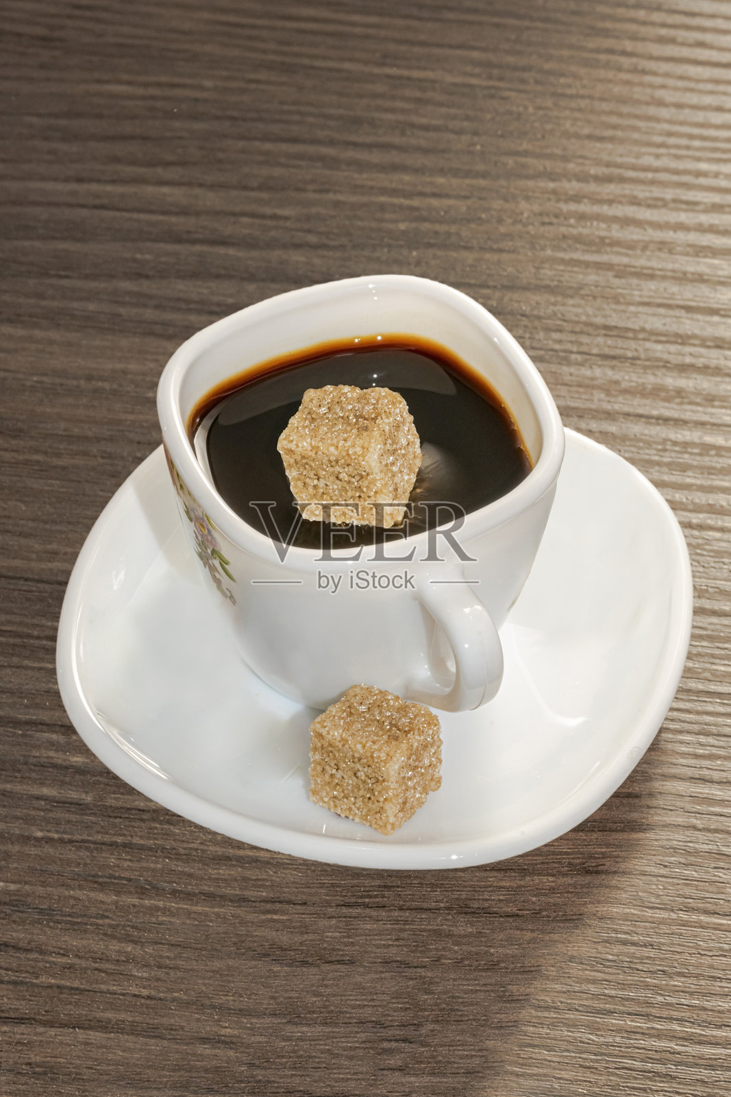 一杯黑咖啡，一粒糖滴入咖啡表面照片摄影图片