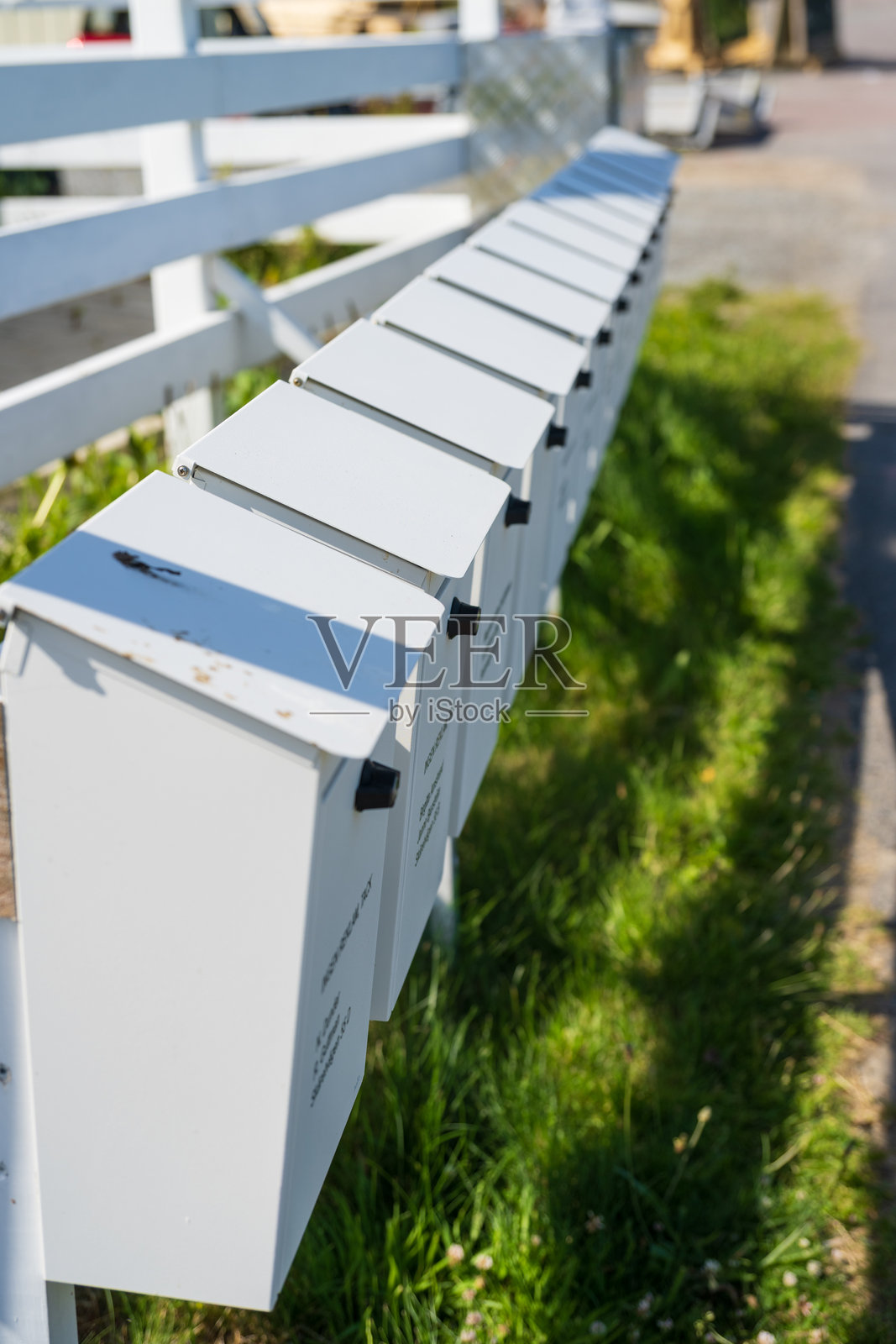 一排排白色的户外住宅邮箱整齐排列。照片摄影图片