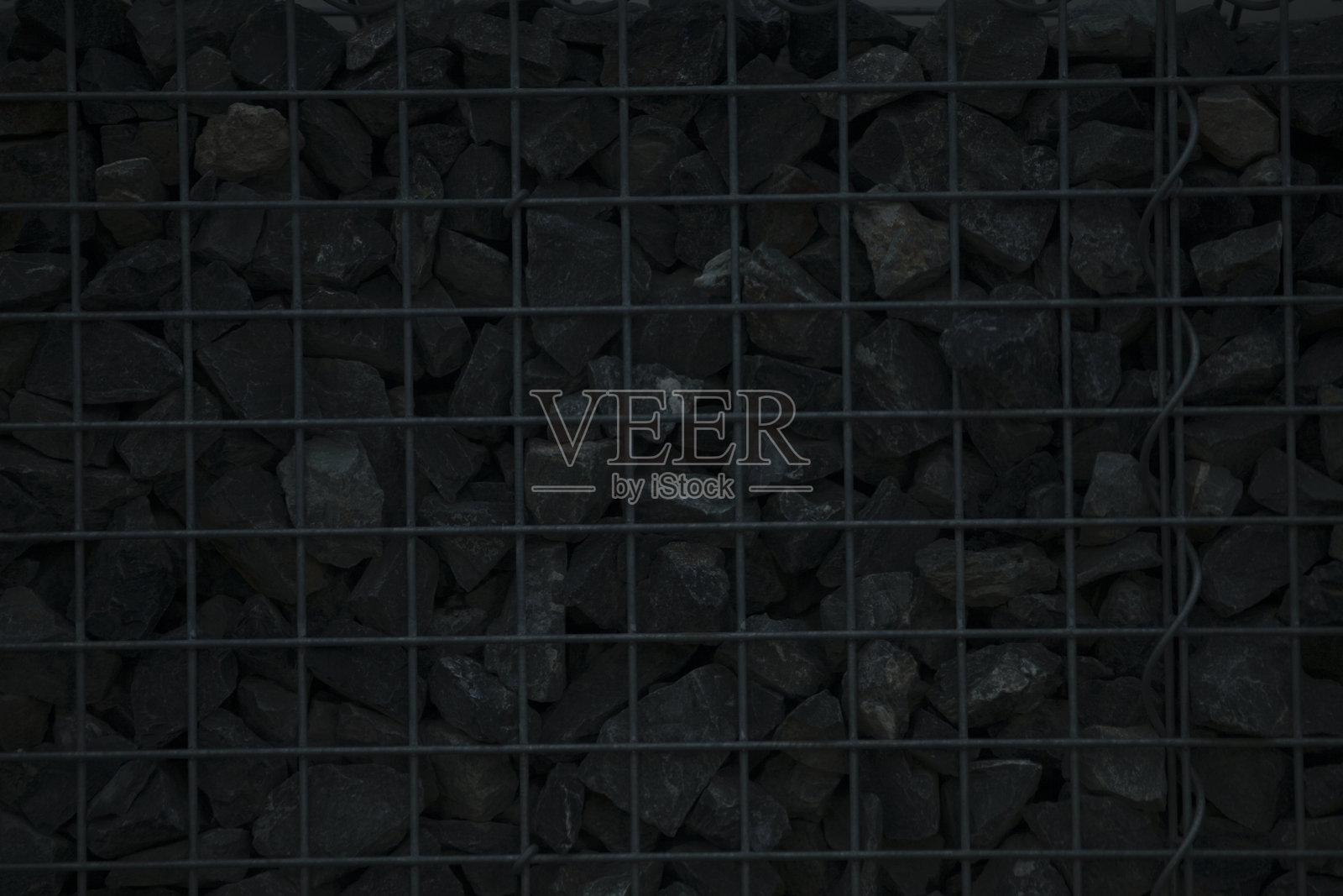 金属栅栏特写，里面装满了黑色石块照片摄影图片