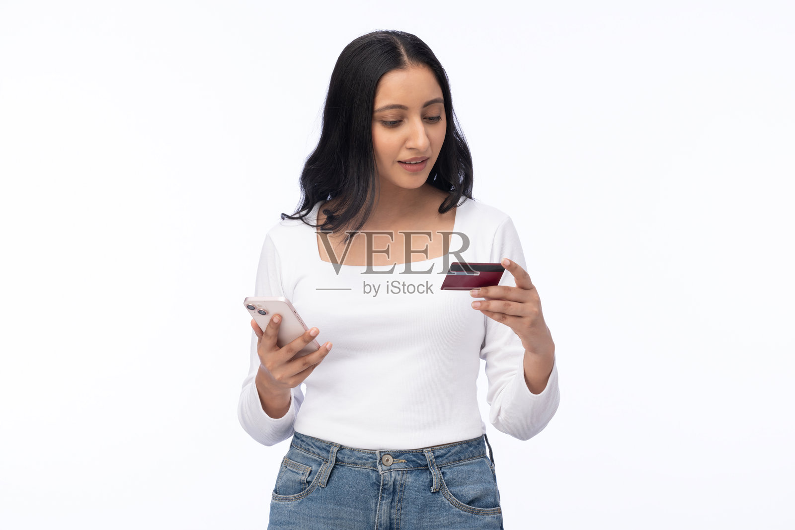 年轻女子手持信用卡和智能手机，白色背景，购物素材照片摄影图片