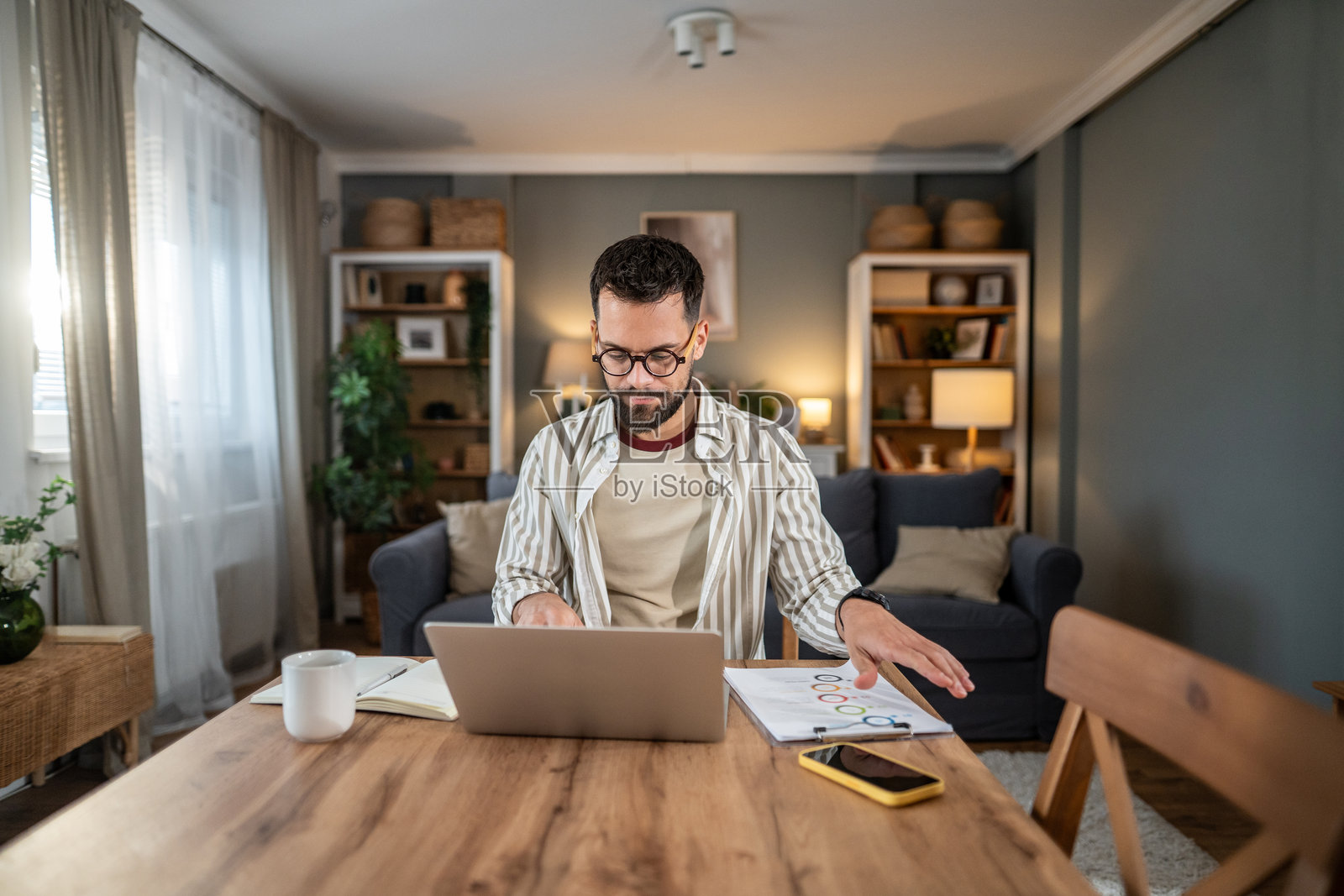 男人在家远程办公，使用笔记本电脑照片摄影图片
