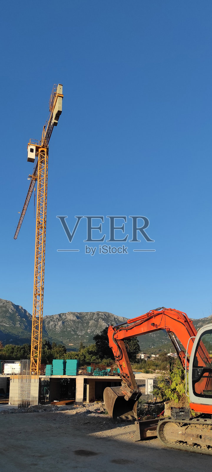 施工现场的塔式起重机和挖掘机照片摄影图片